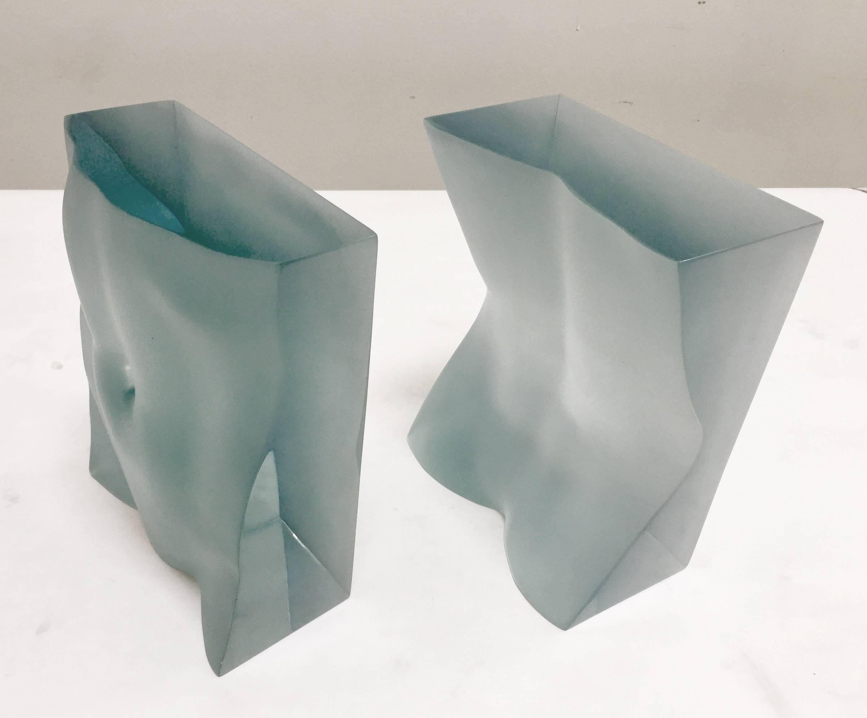 A stunning sculptural pair of bookends designed and produced by artist, Tanya Ragir. They are fabricated in transparent aqua Lucite in a limited edition of 25 but are also available in colored cast stone, white cast stone, or stainless steel