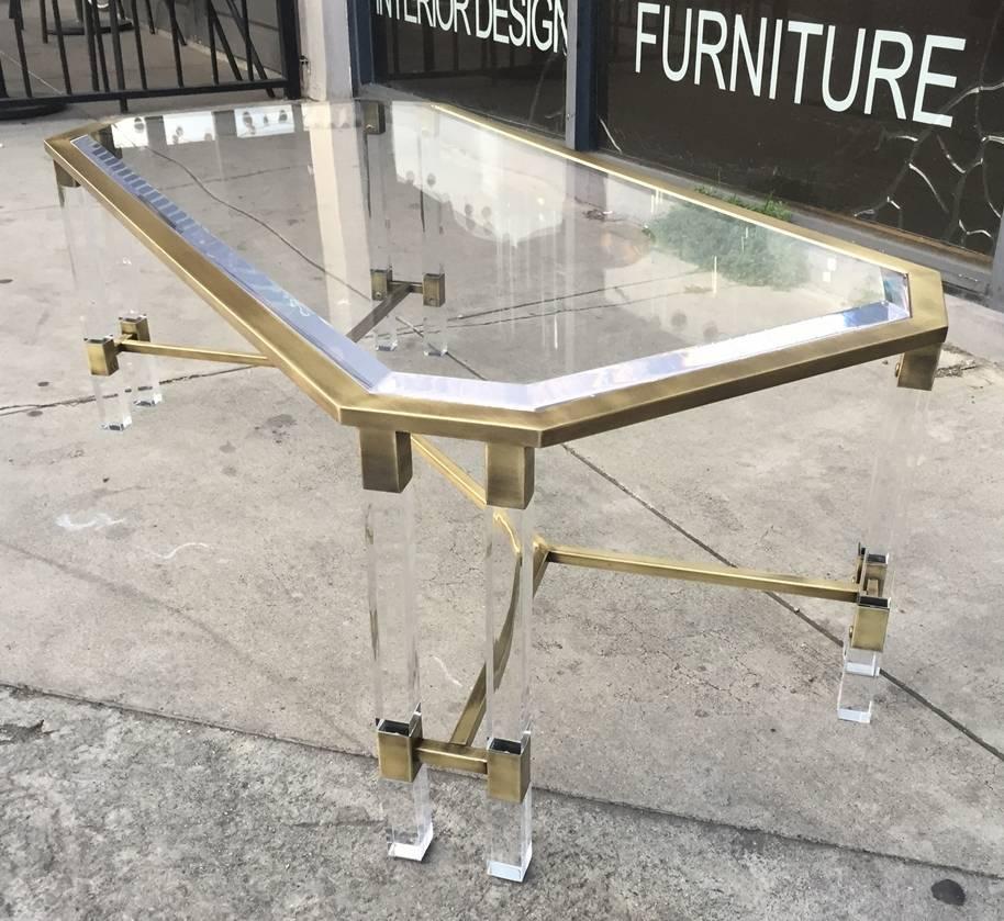 Stunning brass and Lucite coffee table made in Italy in the late 1960s early 1970s.
The coffee table comes with a beautiful Lucite top with bevel edges and a double Lucite legs on each corner and a brass stretcher.
The brass has a nice aged patina