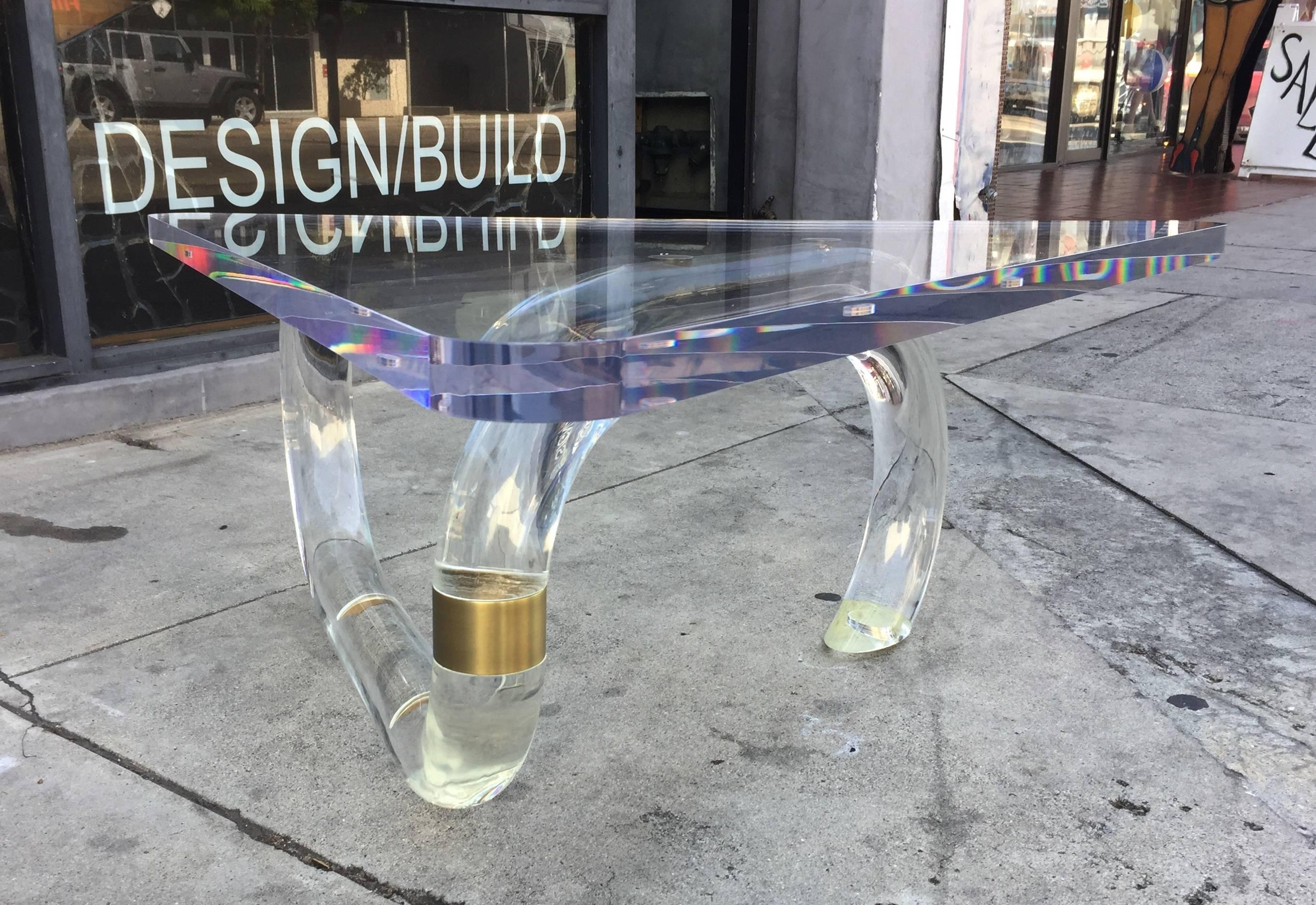 Superbe table basse en lucite et laiton conçue par Amparo Calderon Tapia en exclusivité pour Cain Modern.
La table est exécutée en Lucite et en laiton, la base est composée d'un rond de 3