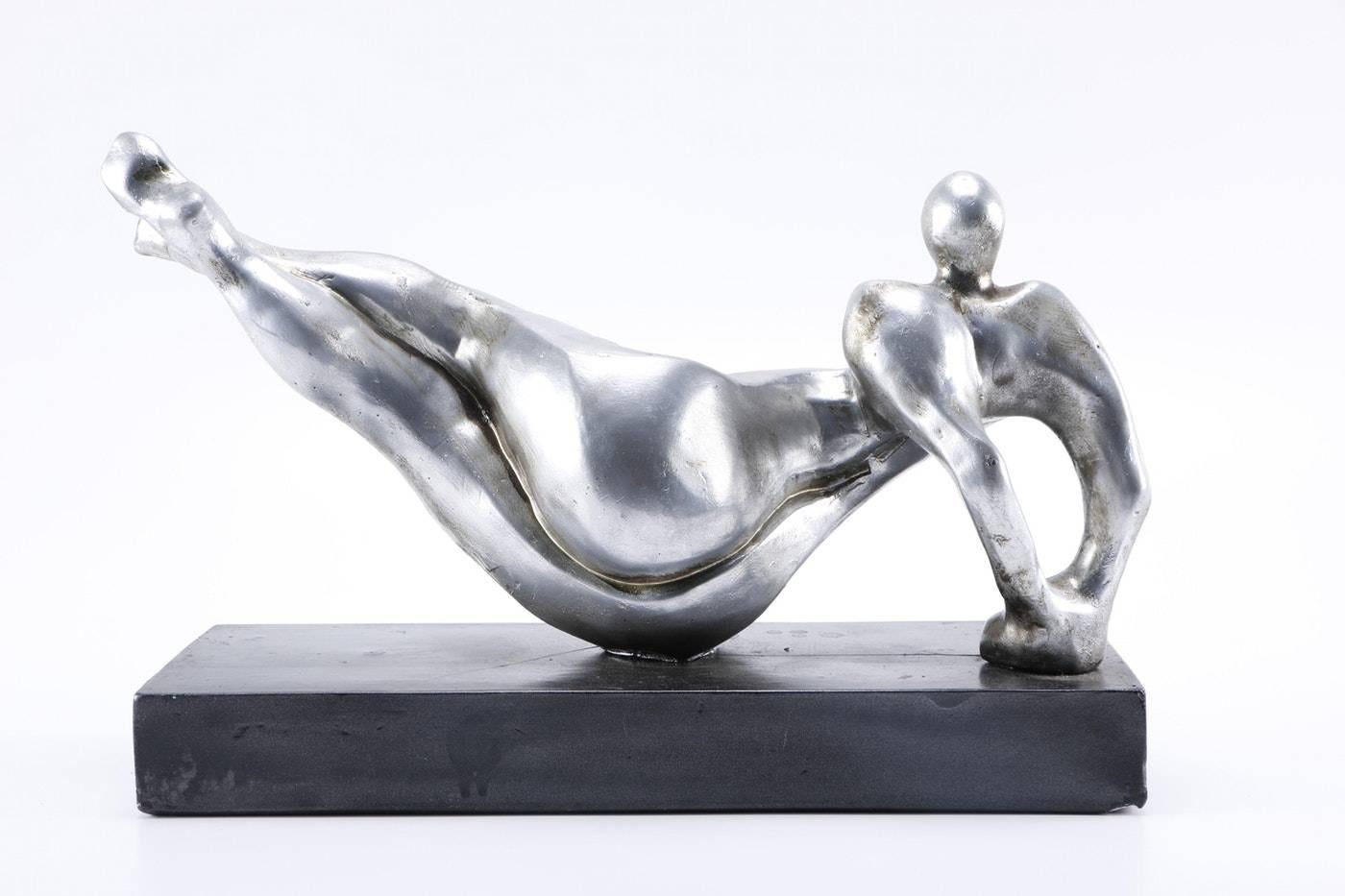 A sculpture by Attila Tivadar, from Attila’s Bay shore Art Studio in San Francisco. Titled Modern Yoga, this depicts an abstracted female figure on her side, with her hands clasped behind, with her legs stretched and raised up to her side.