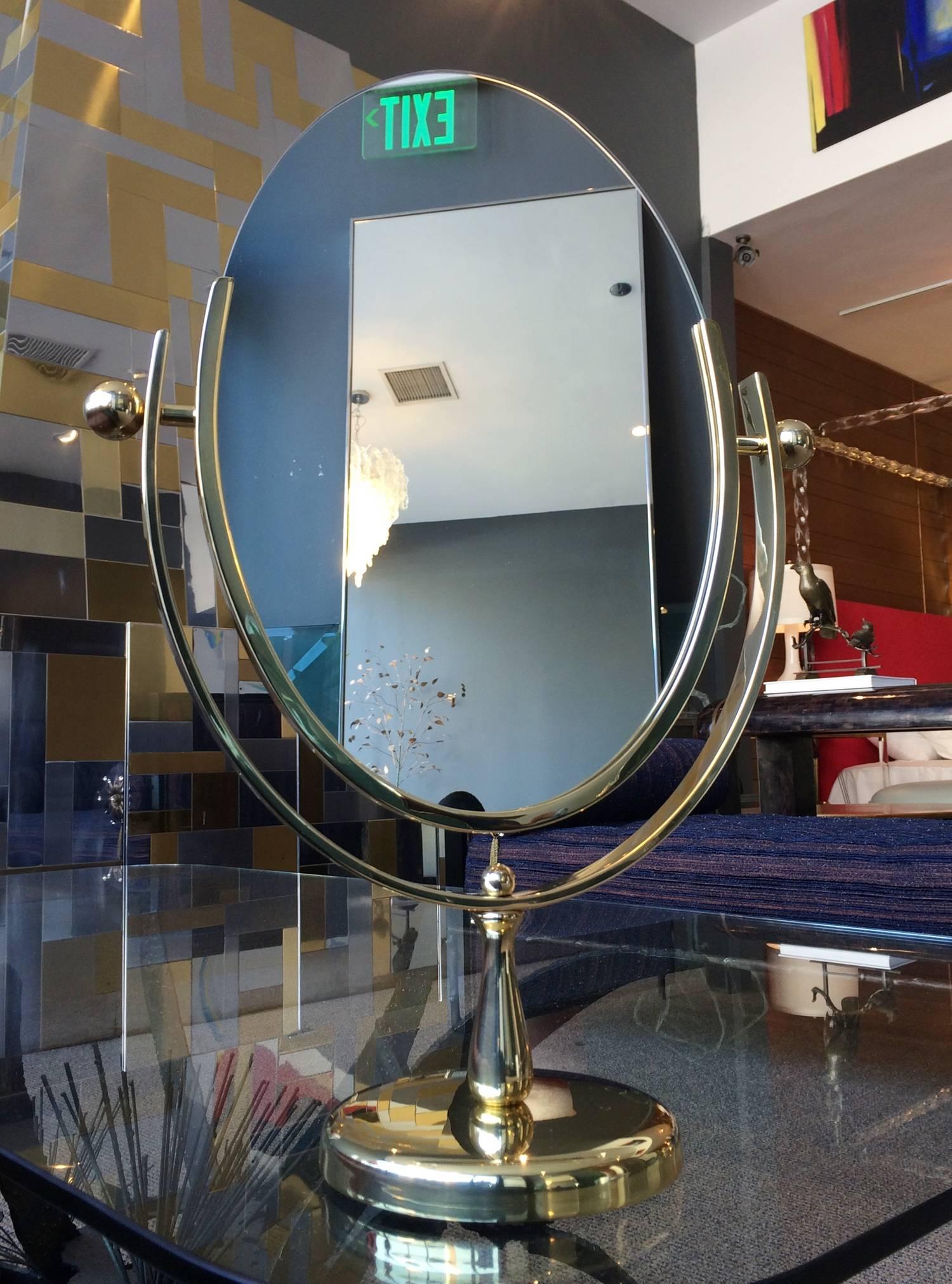Beautiful oval mirror designed and manufactured by Charles Hollis Jones in the 1960s. The mirror has a polished brass finished frame and base, the mirror is double sided and it can be flipped to be used on either side.
The piece is signed by the