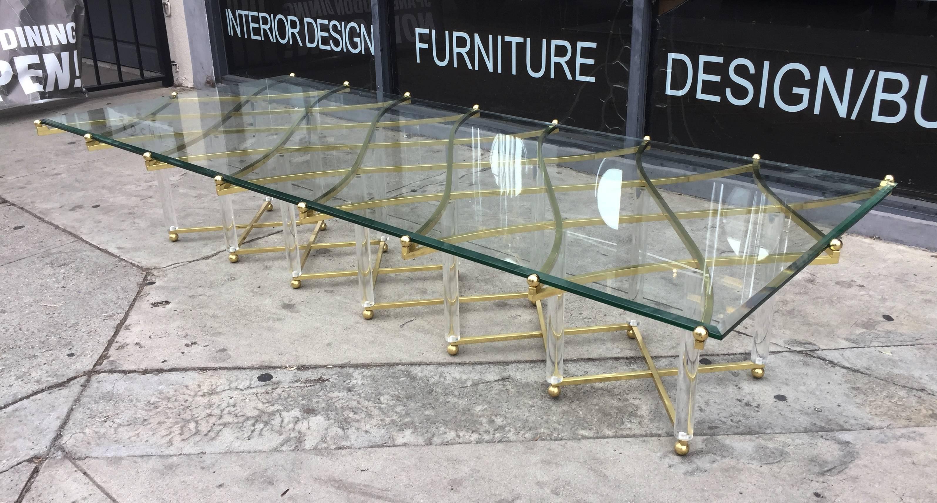 This amazing brass and Lucite coffee table by Hollis Jones is quite possibly his most exquisite design. 
Known for his innovation with the use of Lucite and metal, Hollis Jones is a master at combining elegance and wit. The brass lattice work of the
