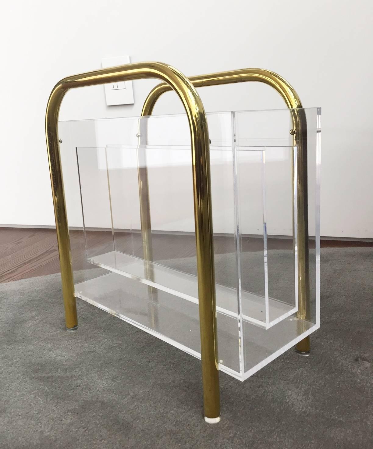 Beautiful and rare magazine holder designed and manufactured by Charles Hollis Jones in the 1970s.

The piece is executed in Lucite having a tubular brass frame having three compartments to store books or magazines.

The piece is in very good