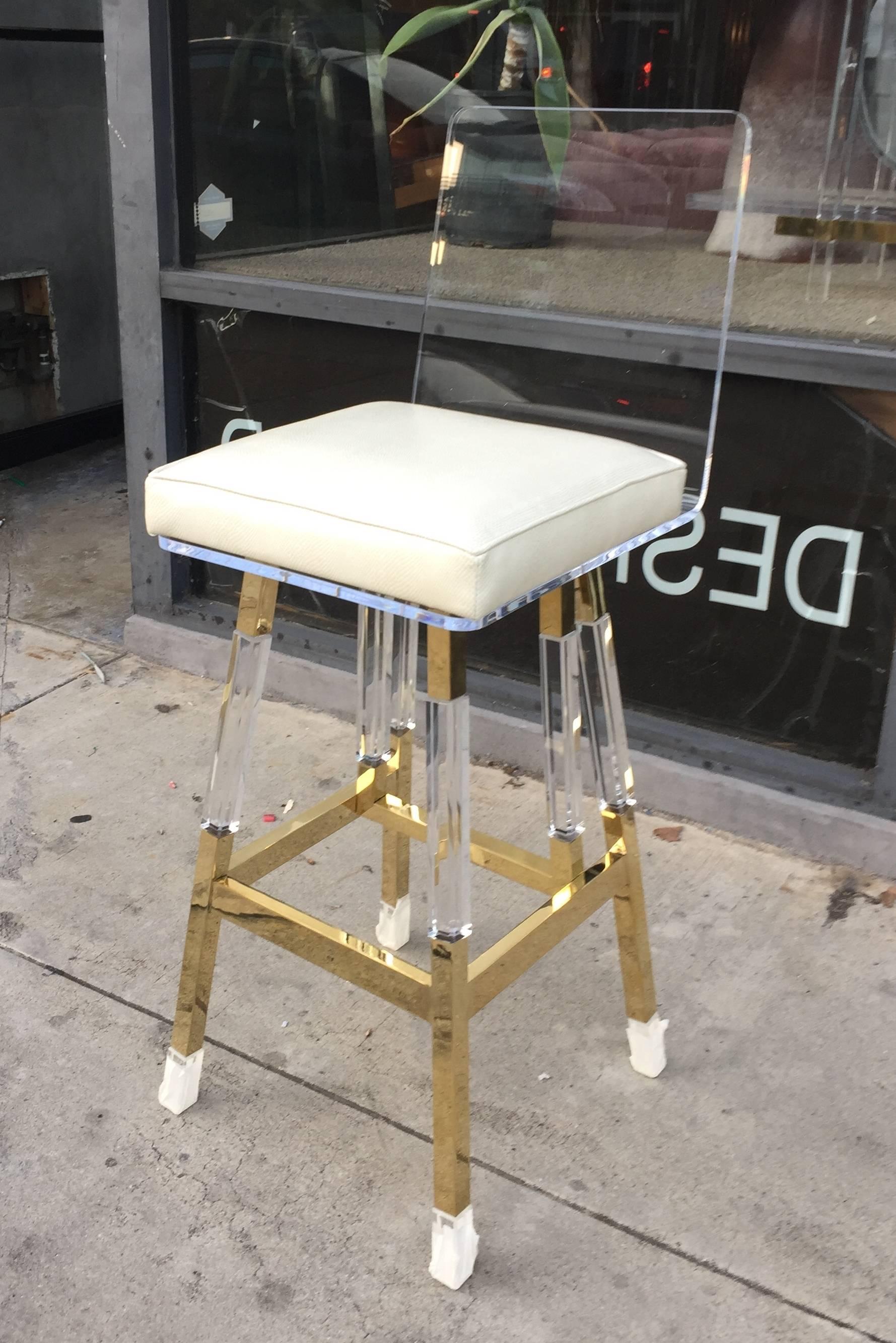 Beautiful set of four bar-stools designed by Charles Hollis Jones in the 1970s, this design is a blend of his Metric collection and the waterfall line and the design was executed beautifully.
The frame is made out of solid brass and polished Lucite