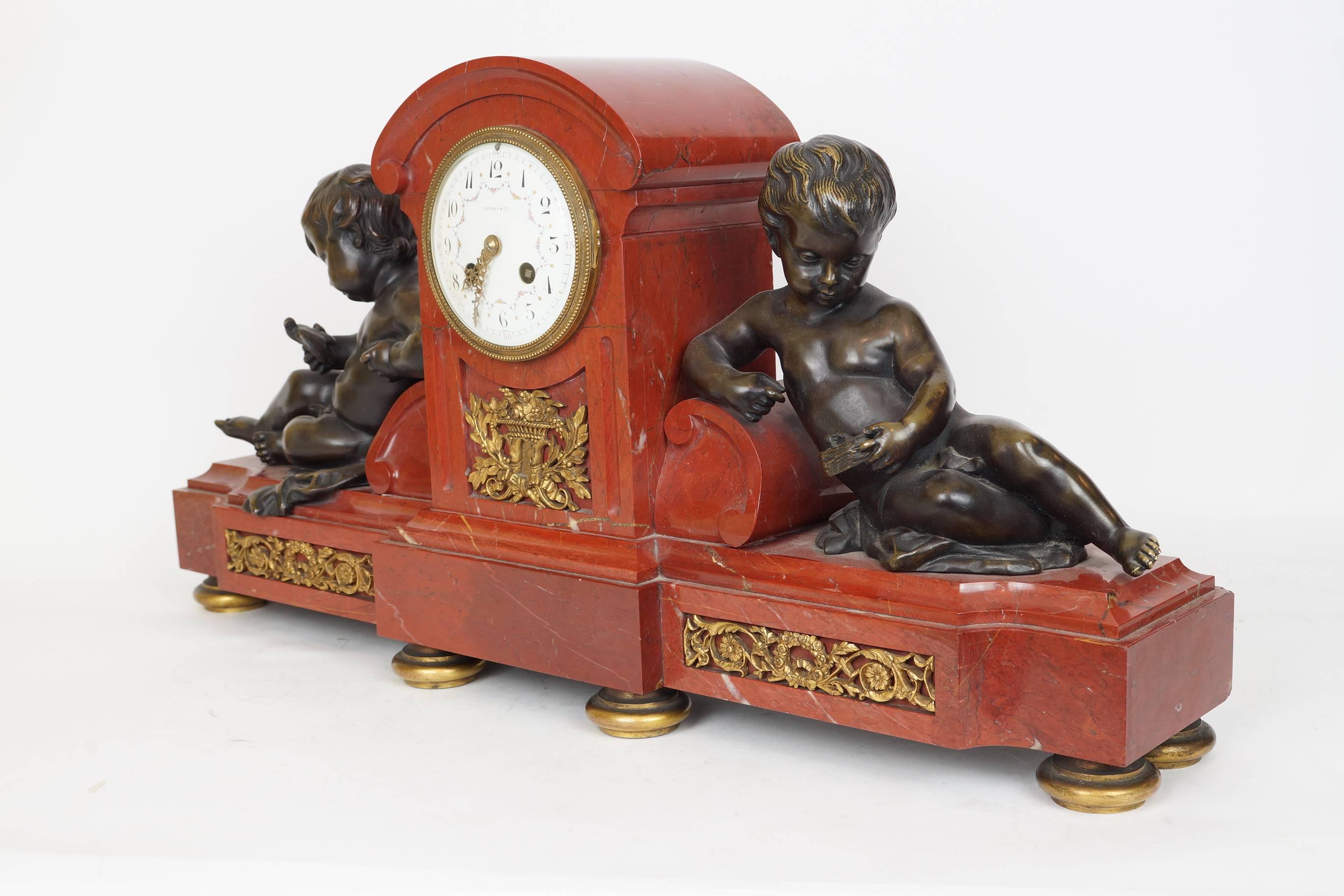 Fine rouge marble and bronze mantel clock Tiffany and Company.
Two patinated seated cherubs on either side, one holding a bird and the other holding a birds nest and a bird.
Tiffany & Co. France on the face of the dial.
Stock number: CC47.