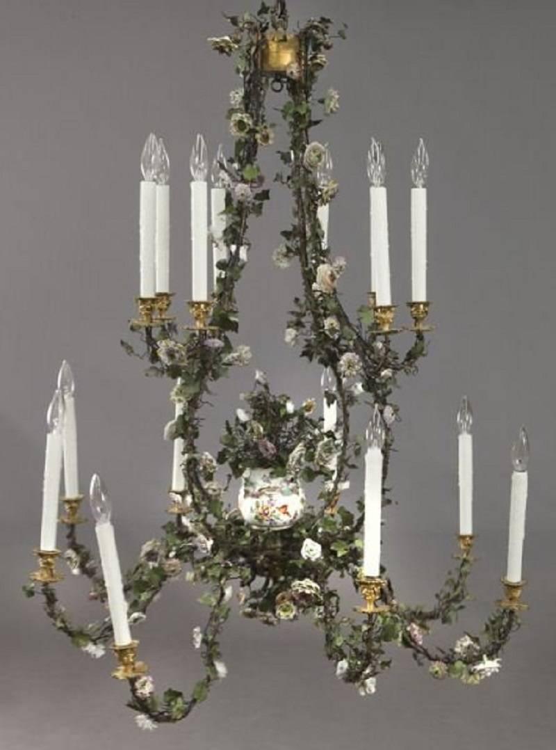 Important North European ormolu painted tole and porcelain sixteen-light chandelier.
Centred with a Dual-handled vase issuing blossoming flowers.
The tole on this wonderful chandelier is from the mid-19th century and the porcelain flowers are