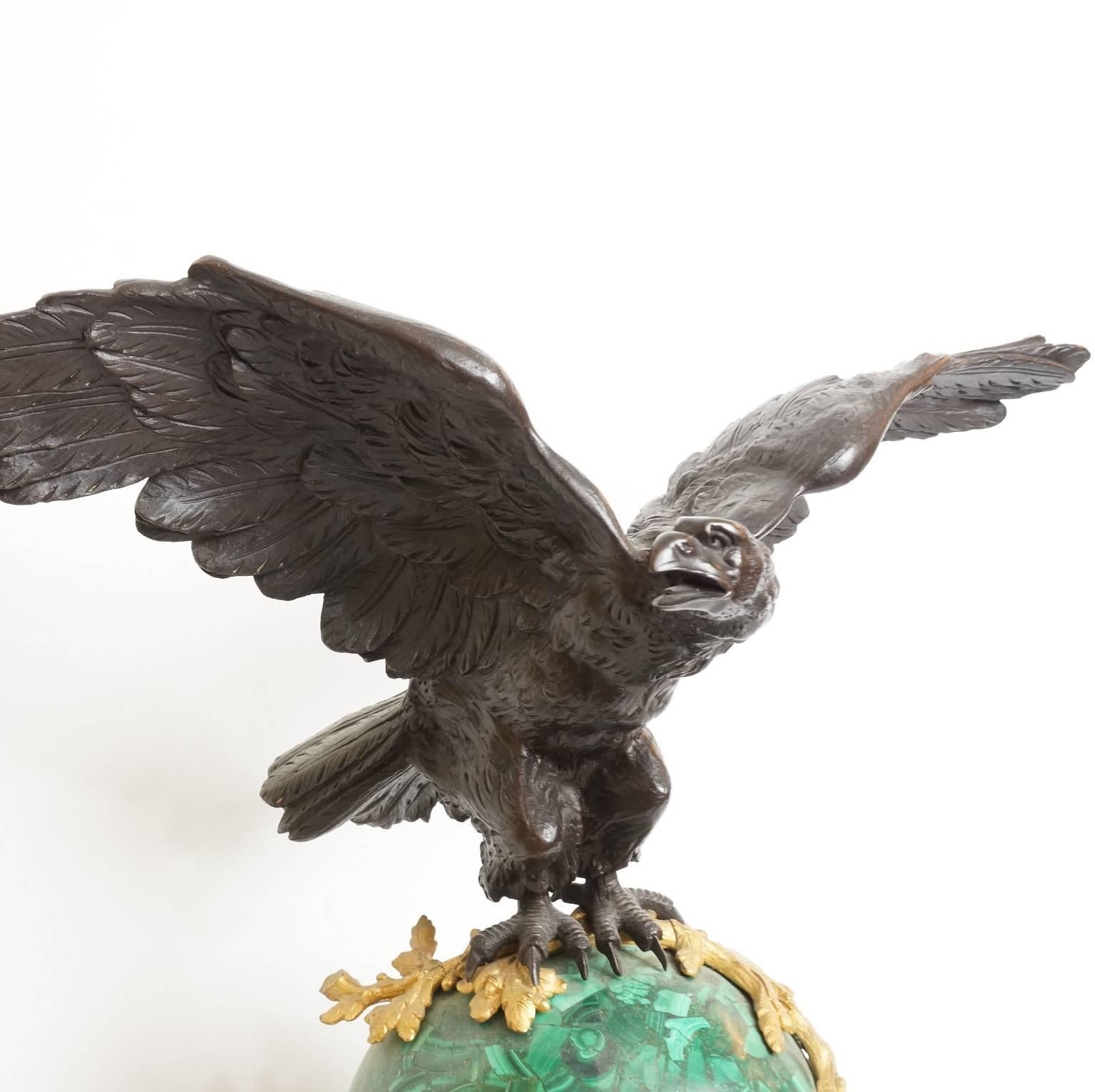 An important patinated bronze and malachite stone and marble mantel clock with an eagle with open wings standing on top.
Stock number: CC40.