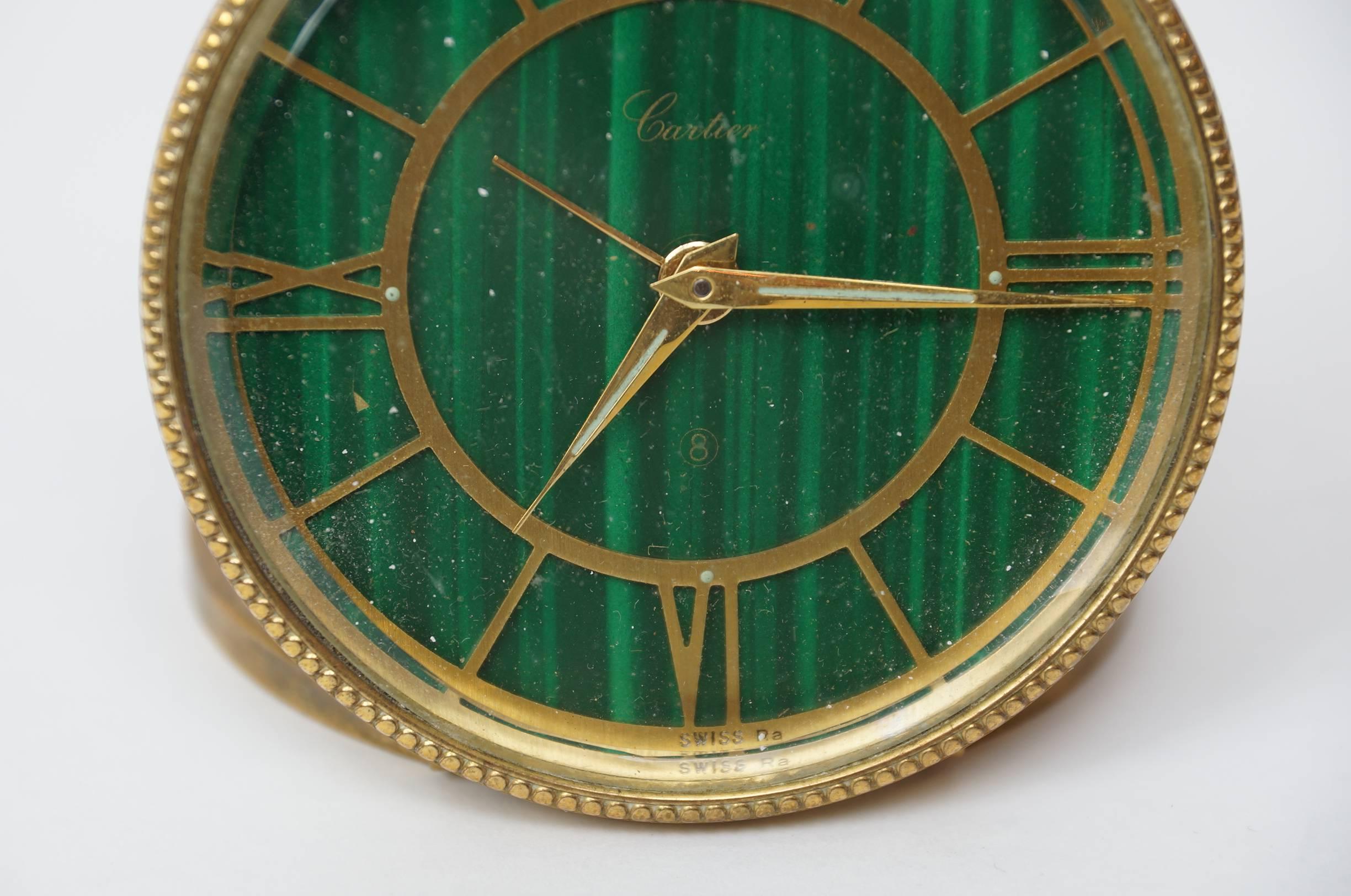 A Cartier green malachite and brass round desk traveling clock.
