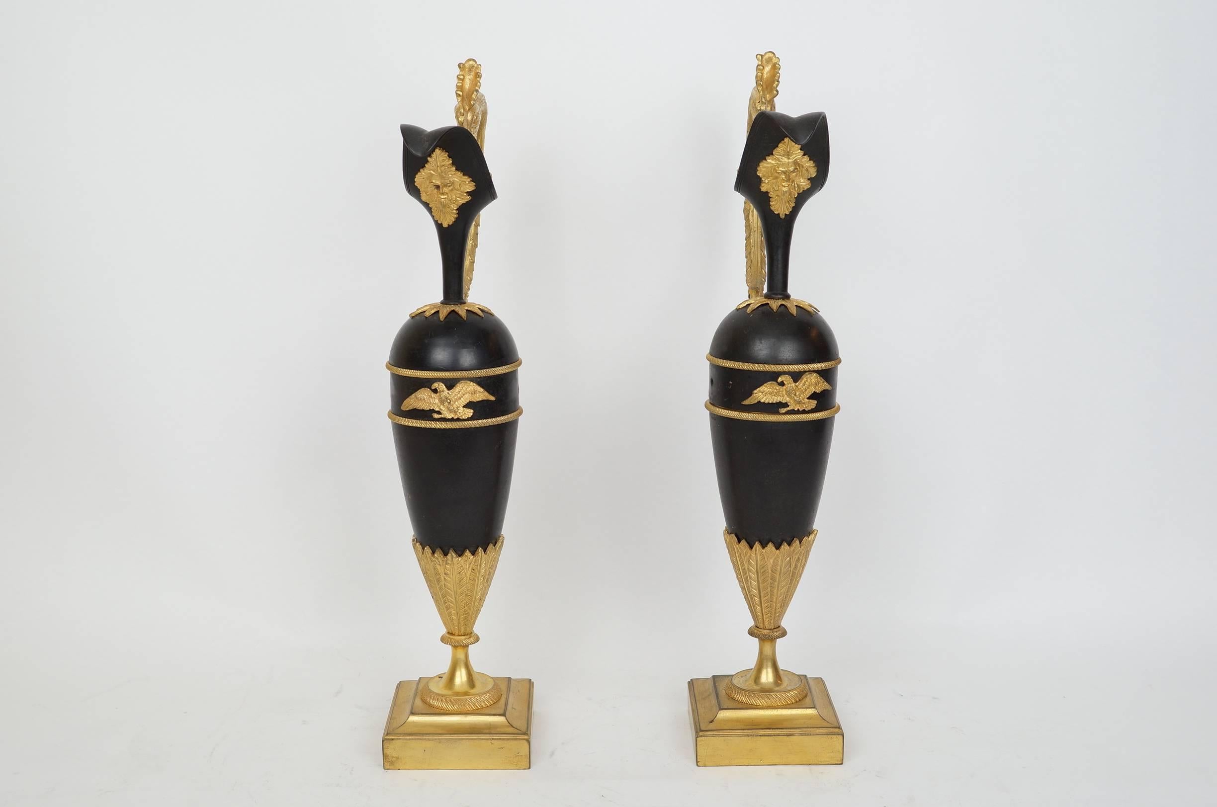 Pair of Russian Empire style patinated and gilt bronze ewers with rooster head.