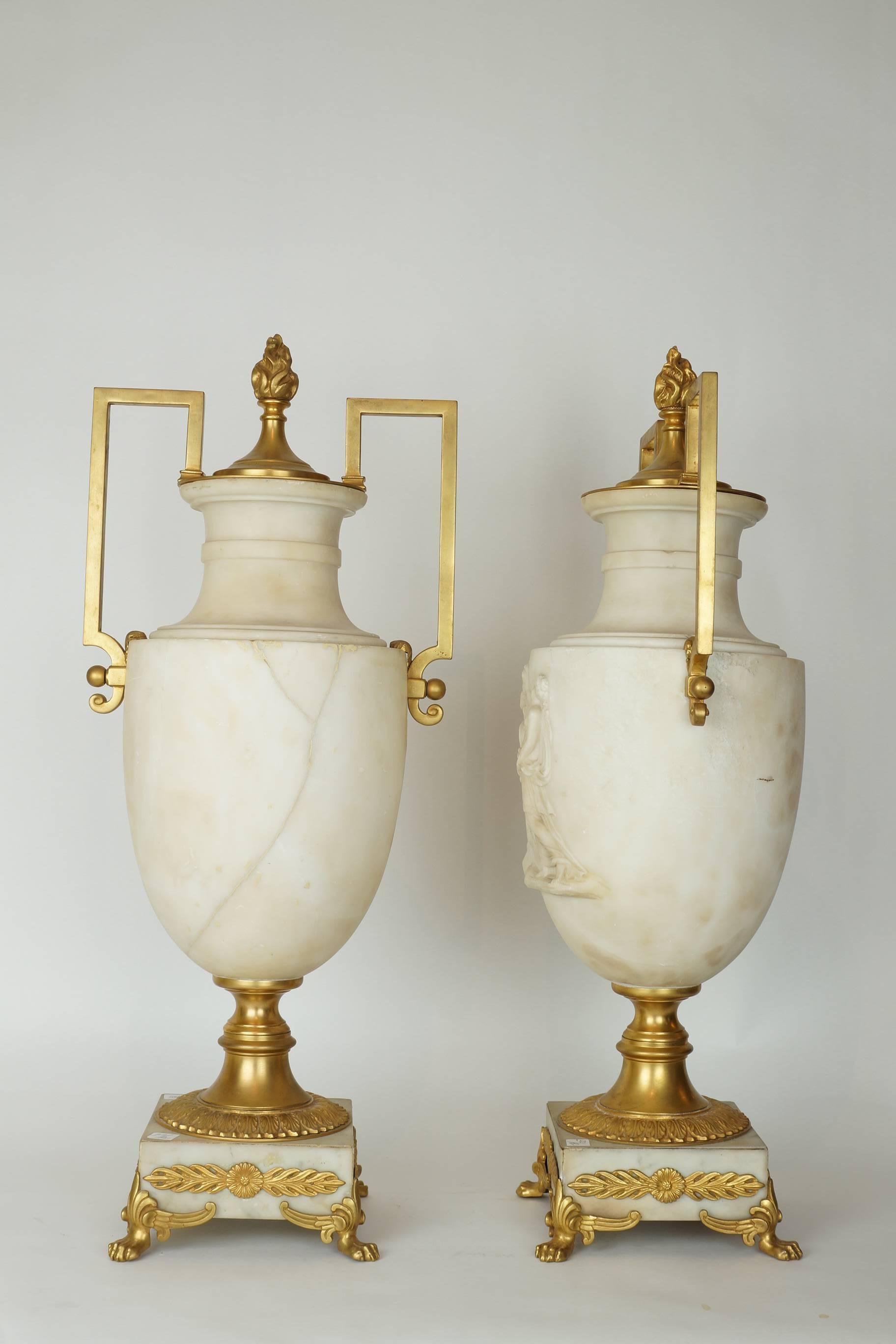 Pair of Italian Alabaster and bronze neoclassical urn lamps with raised neoclassical scenes and bronze handles.
