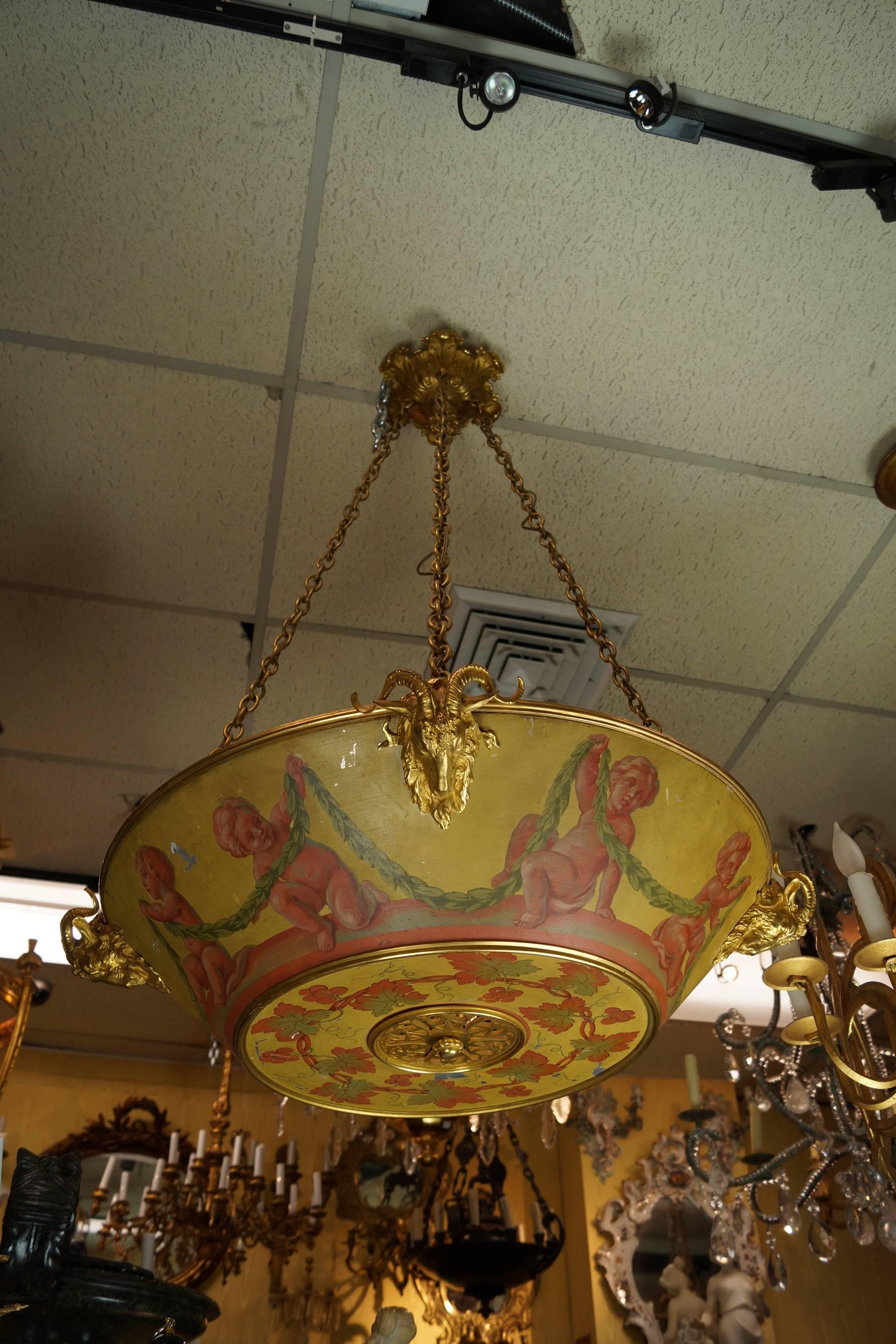 Neoclassical painted tole and bronze chandelier with cherubs and garland
with ram’s head and leaf design attributed to Caldwell.
Stock number: L403.