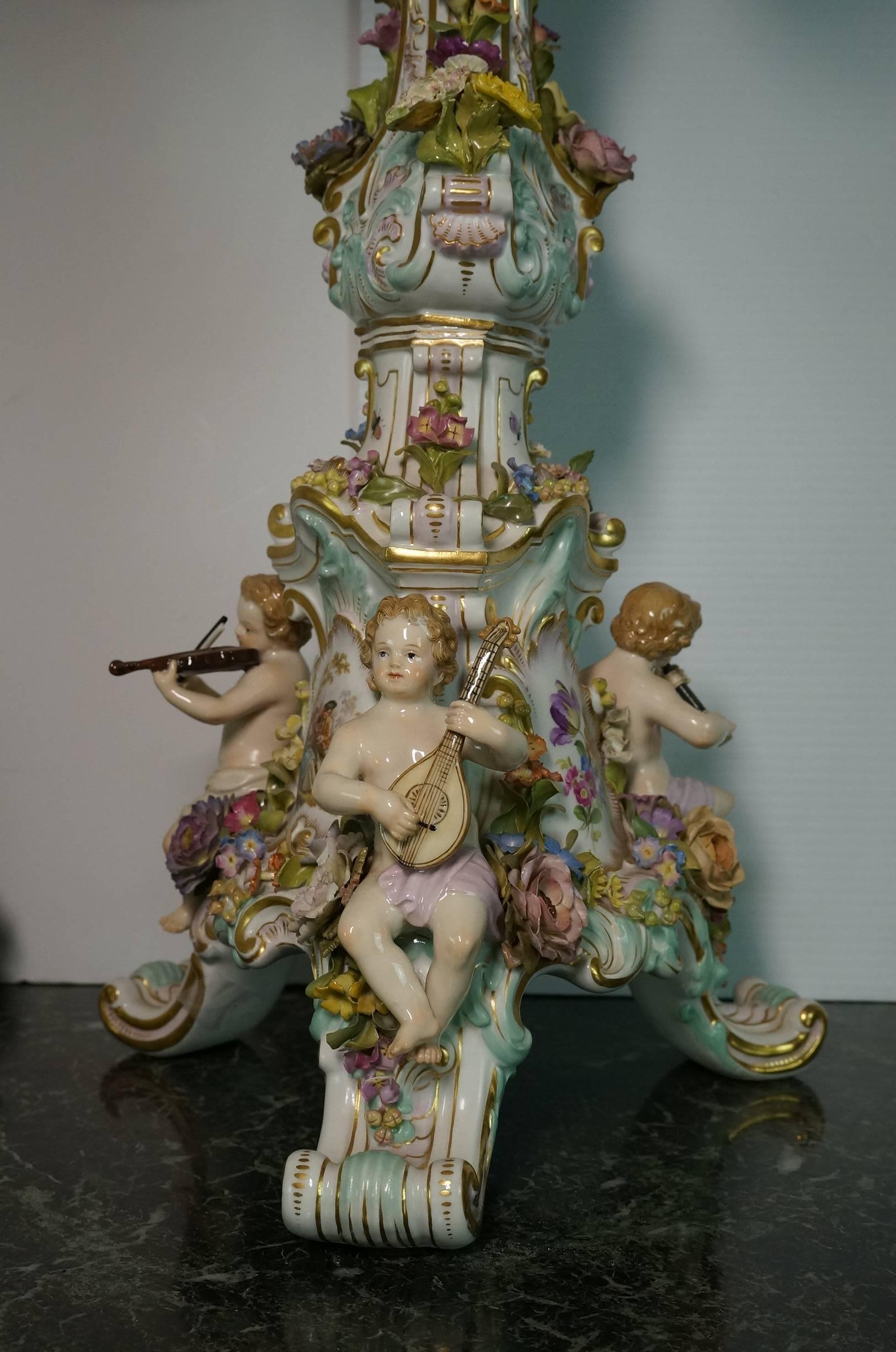 A very large and finest quality Meissen Porcelain figural and flower encrusted three-piece clock garniture set.

comprising a clock with four putti emblematic of the four seasons and two twelve-light candelabras each applied with three putto