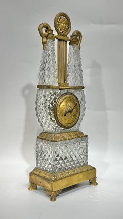 Kaminuhr in Lyra-Form aus geschliffenem Glas mit vergoldeten Metallbeschlägen aus dem frühen 19. Jahrhundert