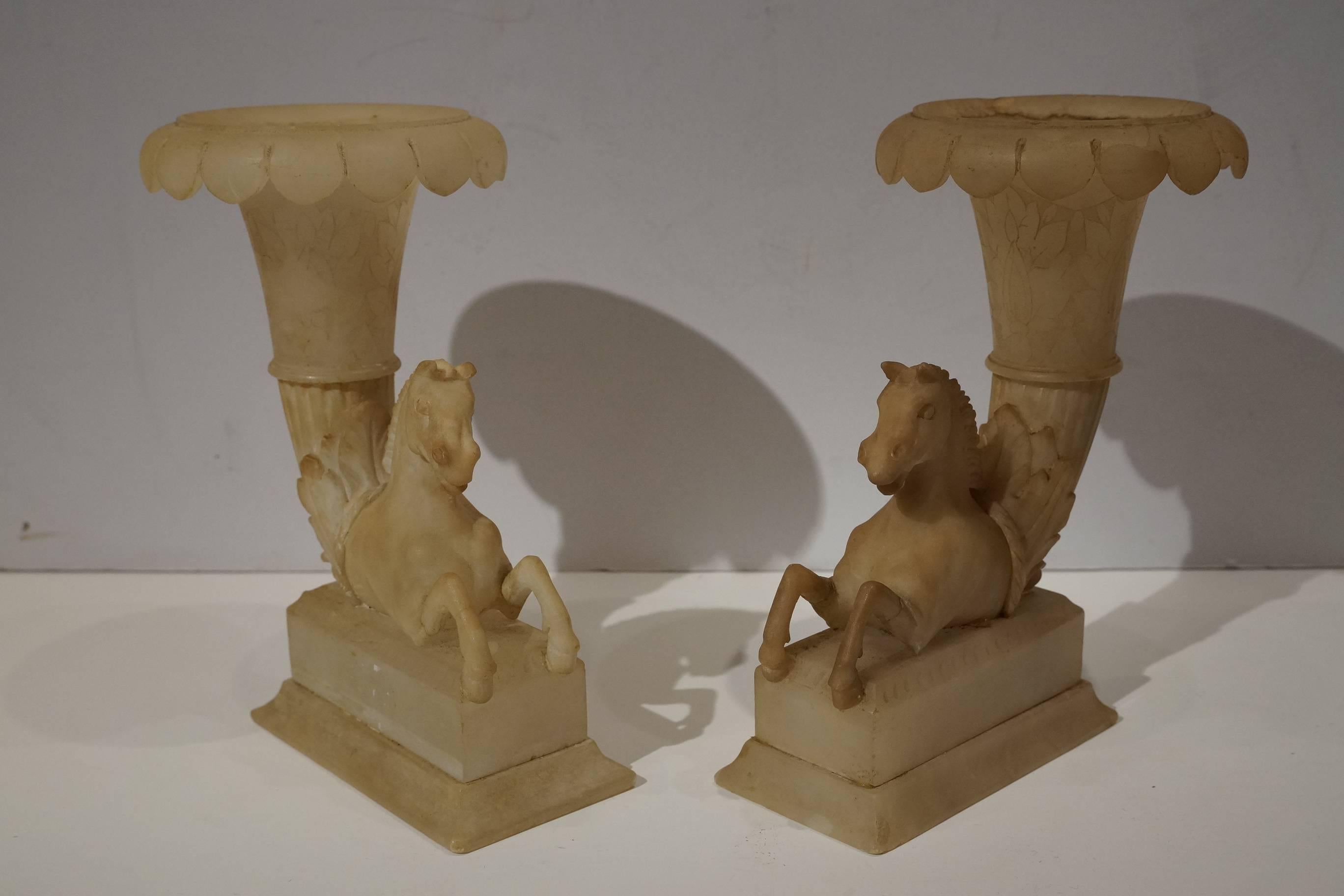 A pair of Italian Grand Tour Alabaster Cornucopia vases
having foliate rim vases supported by hippocampi, on rectangular plinth bases.
Measures: Height 7 inches.