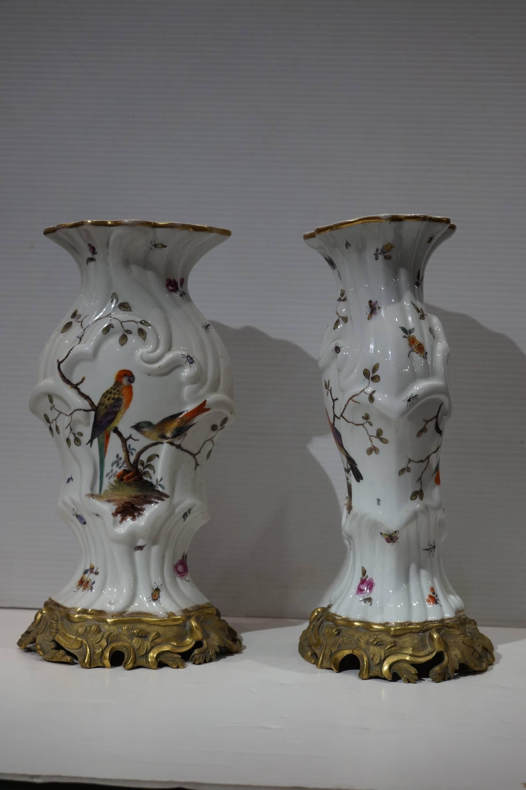 Pair of aesthetic painted porcelain and bronze covered urns with bird and flower decorations.