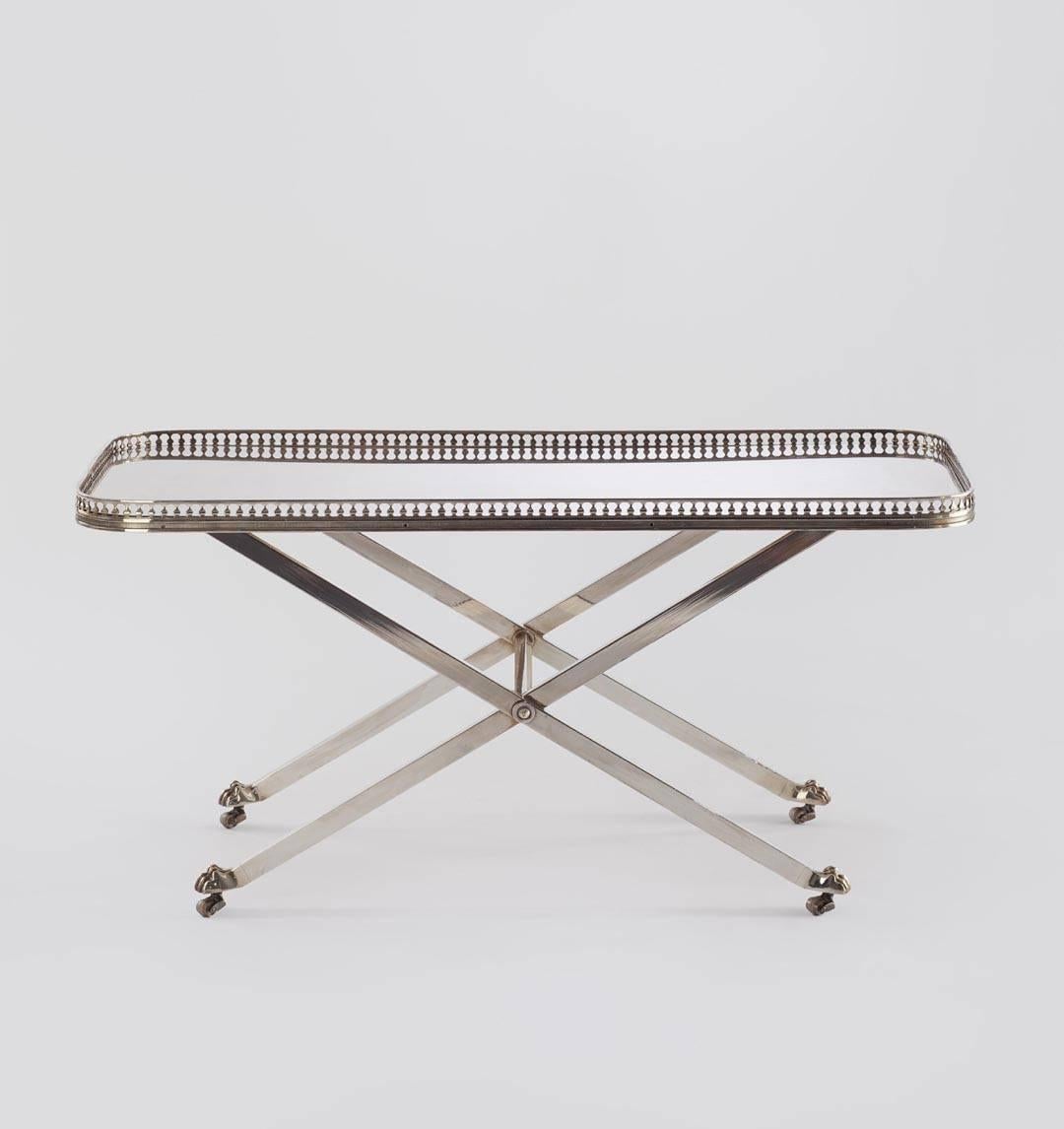 Silver tea table by Maria Pergay with balcony edge, X legs and tiger feet.