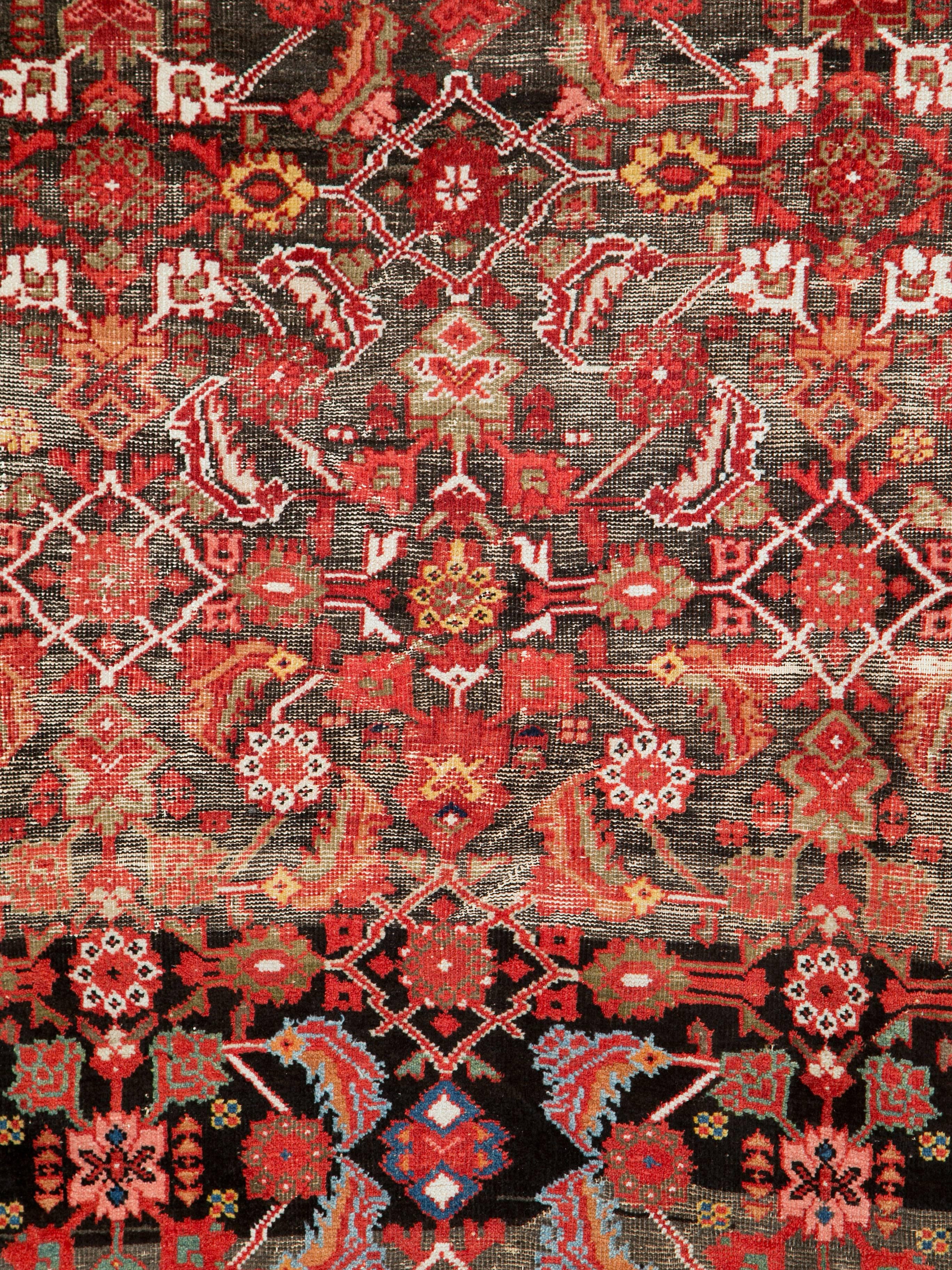 Ein antiker persischer Mahal-Teppich aus dem ersten Viertel des 20. Jahrhunderts mit einem verwitterten und beschädigten Aussehen.