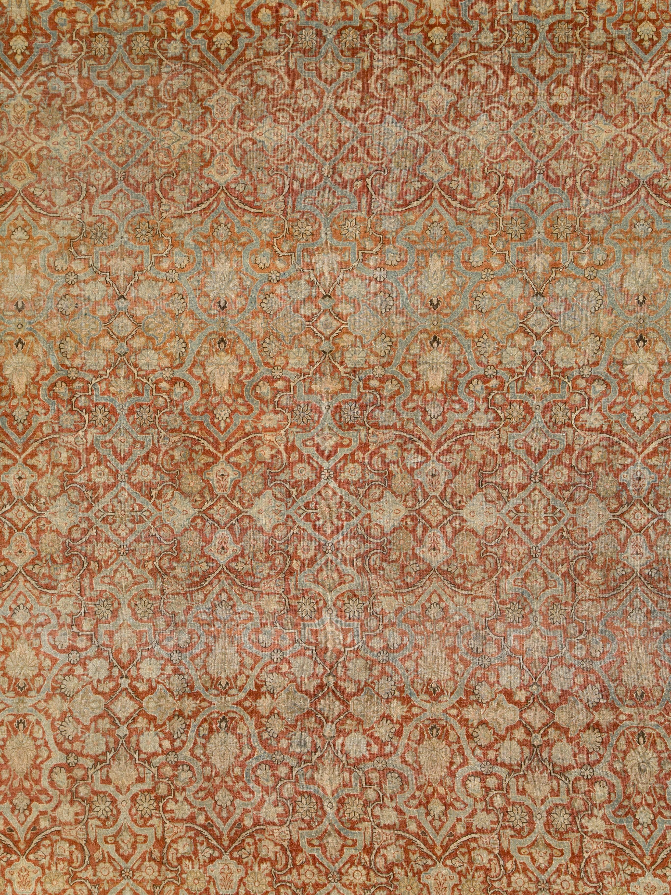 An antique washed Persian Kashan carpet from the first quarter of the 20th century.