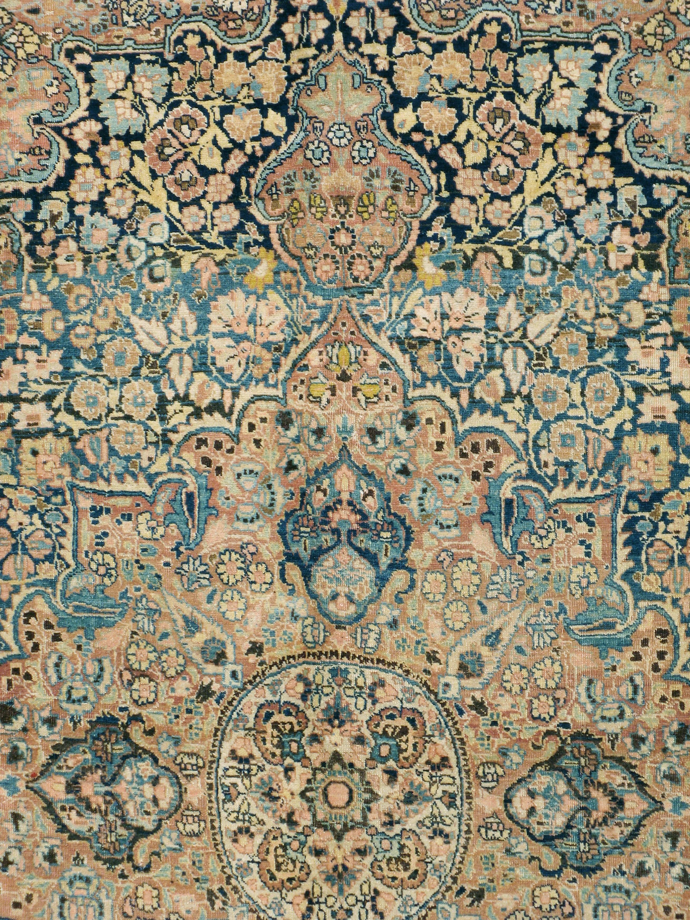 A vintage Persian Mashad carpet from the second quarter of the 20th century. Mashad carpets are famous for their intricate, fully realized medallion designs. This navy ground piece is a perfect exemplar of the genre with a salmon eight point
