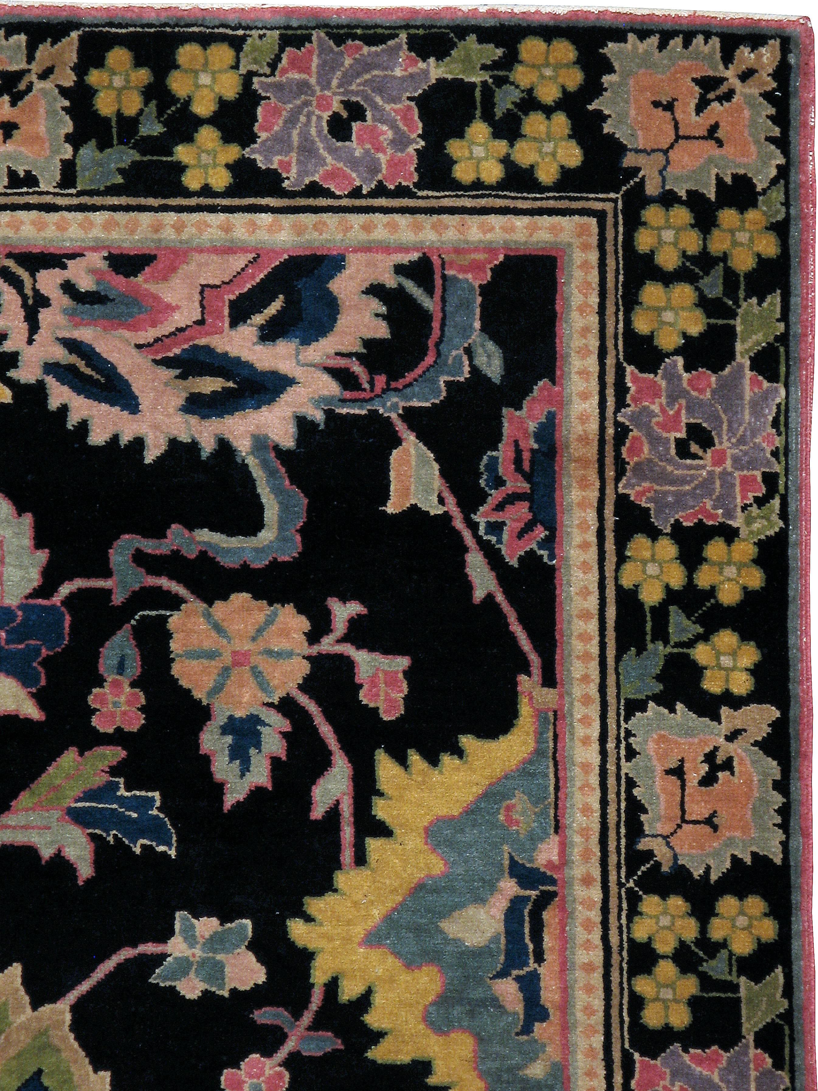 Ein alter indischer Lahore-Teppich aus dem zweiten Viertel des 20. Jahrhunderts mit einem auffälligen Blumenmuster auf einem schwarzen Feld.