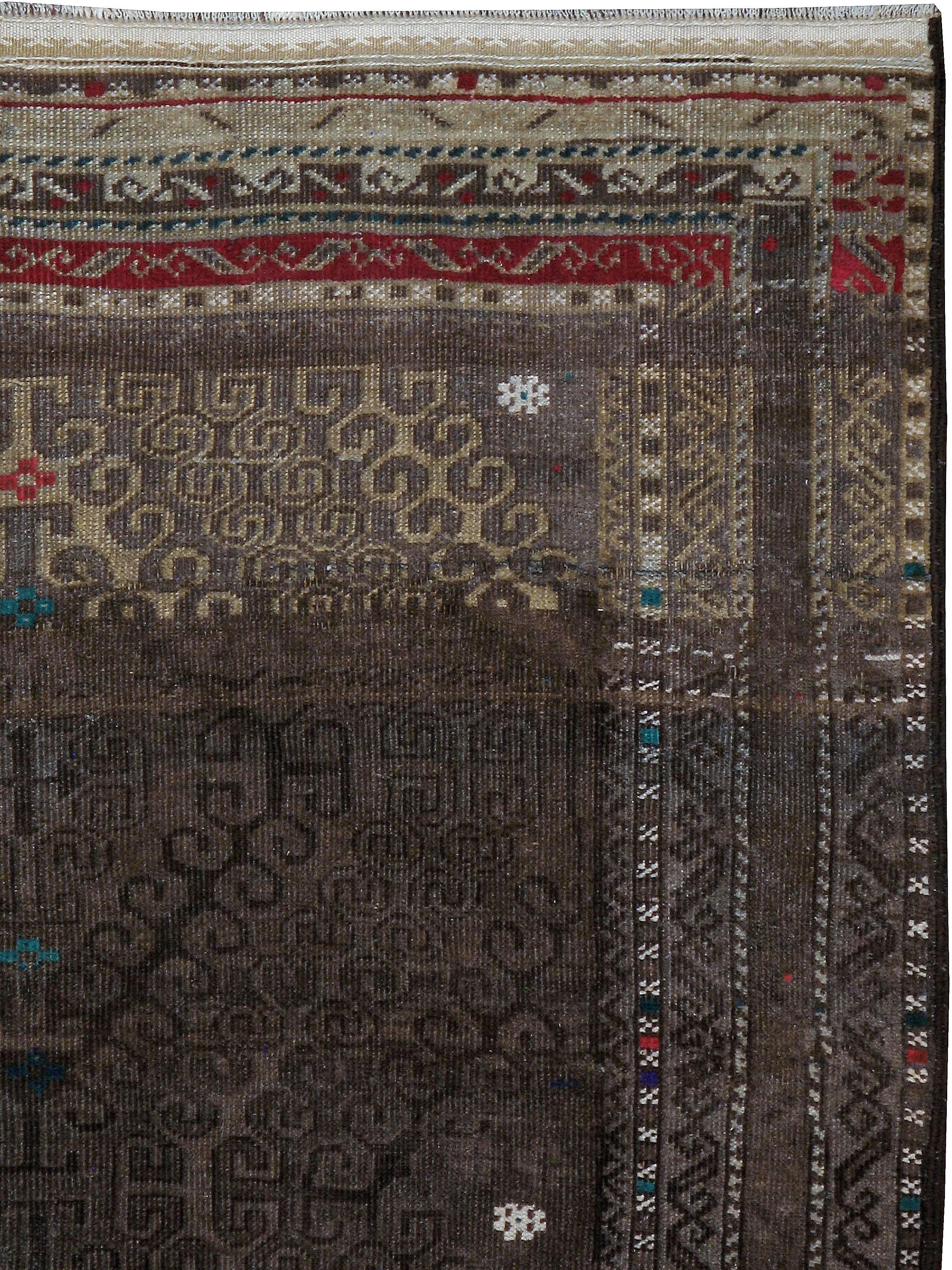 A vintage Persian Baluch carpet from the mid-20th century.