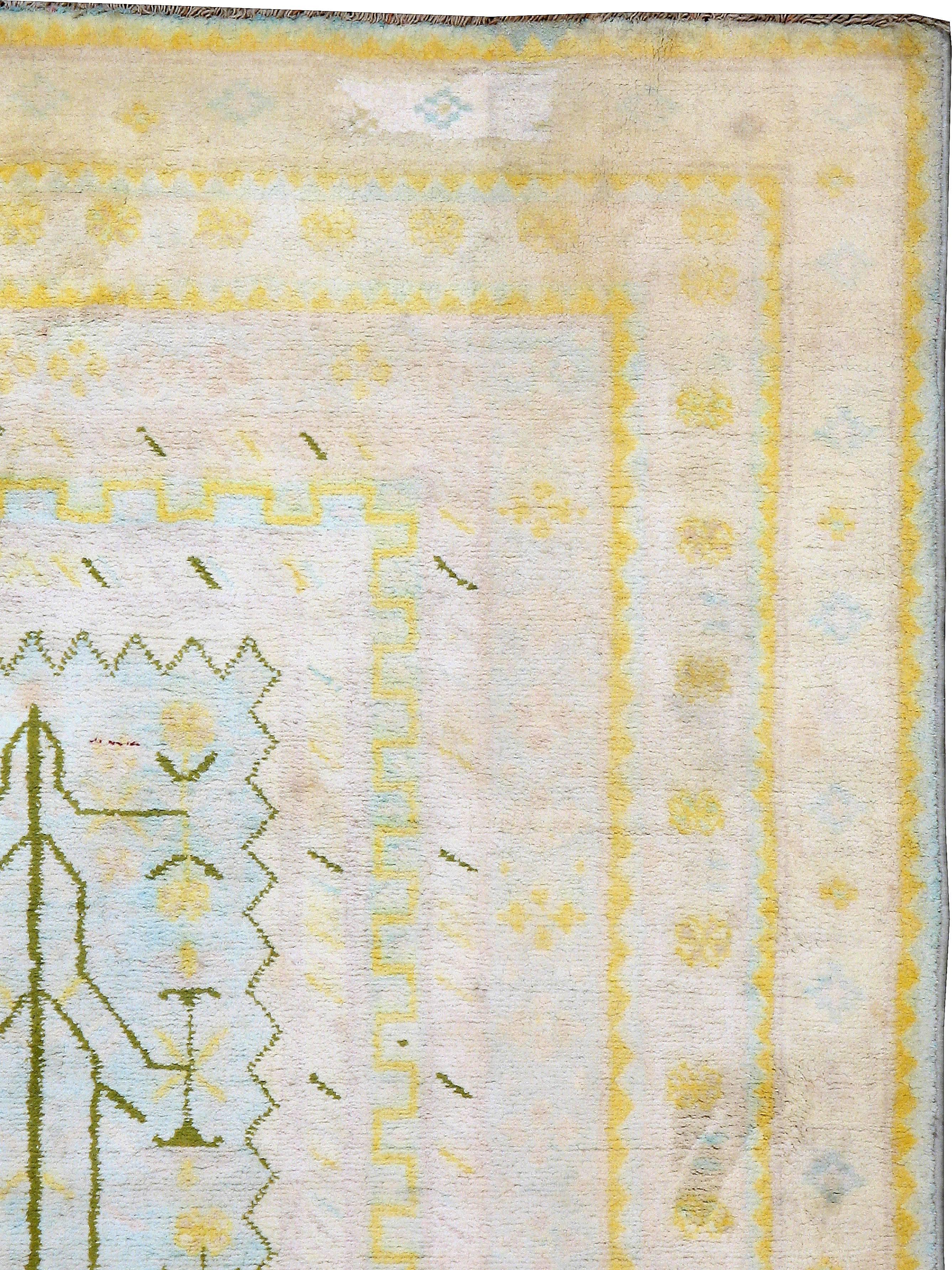 A vintage Indian Cotton Agra carpet, from the second quarter of the 20th century, featuring a soft texture with an ivory field with hints of sap green and sky blue.