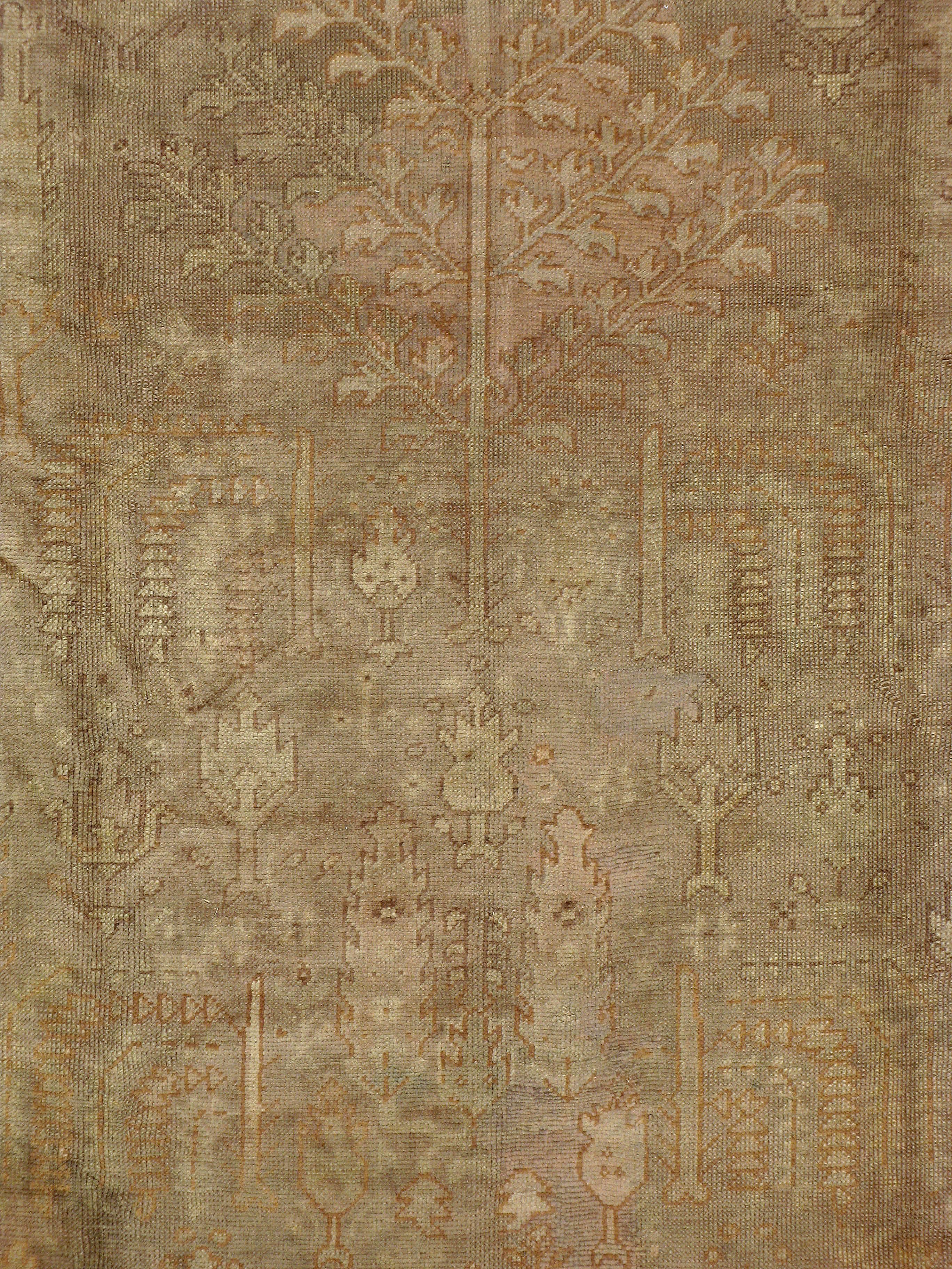 An antique Turkish Oushak carpet from the second quarter of the 20th century. It's weathered appeal works well with vintage decor.