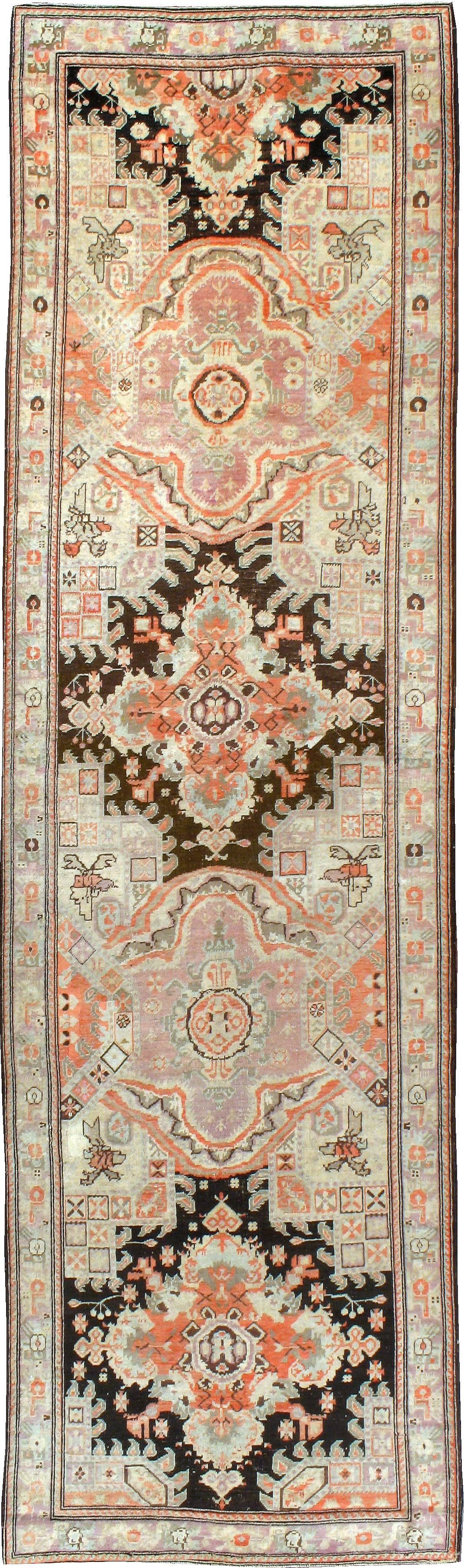 An antique Russian Karabagh rug from the first quarter of the 20th century featuring tones of coral, browns and light purple.
