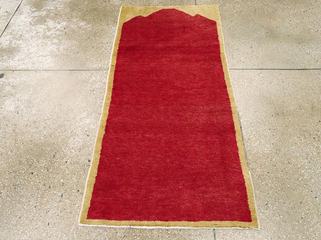 Ein türkisch-anatolischer Teppich im Vintage-Stil. Zwei Farben: rot und sandfarbenes Beige. Eine dreifach zugespitzte, hohe, schlichte rote Nische biegt sich zu einem facettierten Scheitelpunkt nahe dem oberen Ende des Teppichs. Keine Grenzen. Keine