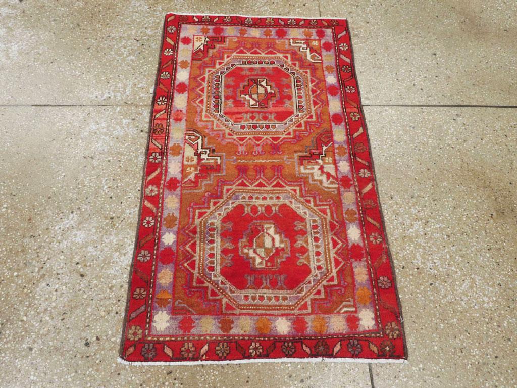 Una alfombra persa Tabriz vintage. Dos gules turcomanos Salor torreados acentuados en rojo y azules más claros, con gules menores fraccionados, dominan el campo de óxido de esta alfombra vintage de Tabriz. Un borde interior azul claro de coloridas