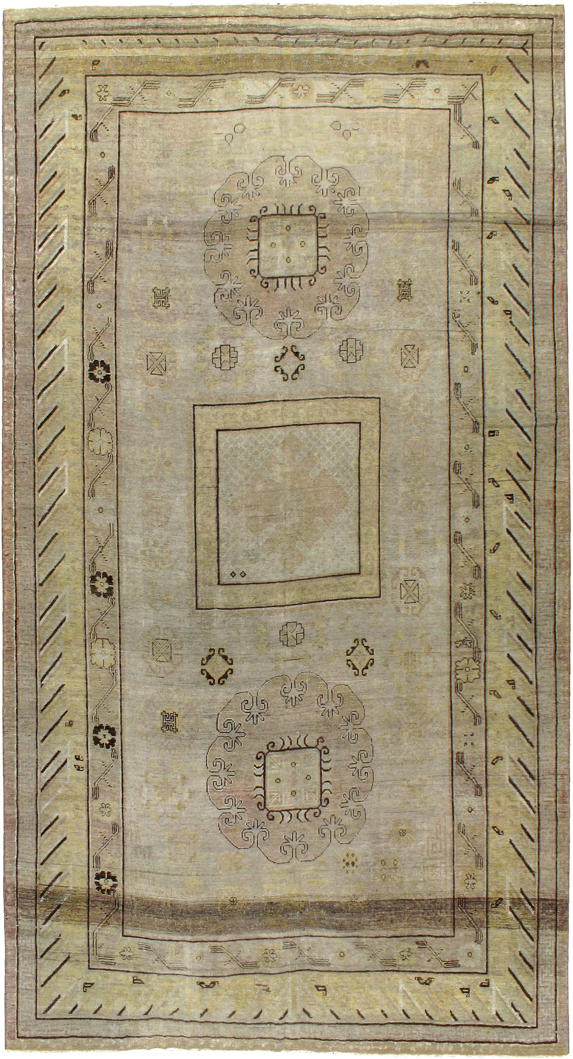 An antique East Turkestan Khotan carpet from the turn of the 20th century. Antique Khotan rugs and carpets were produced in the oasis town of Eastern Turkestan, today part of the Xinjiang region in Western China. This area has had a steady