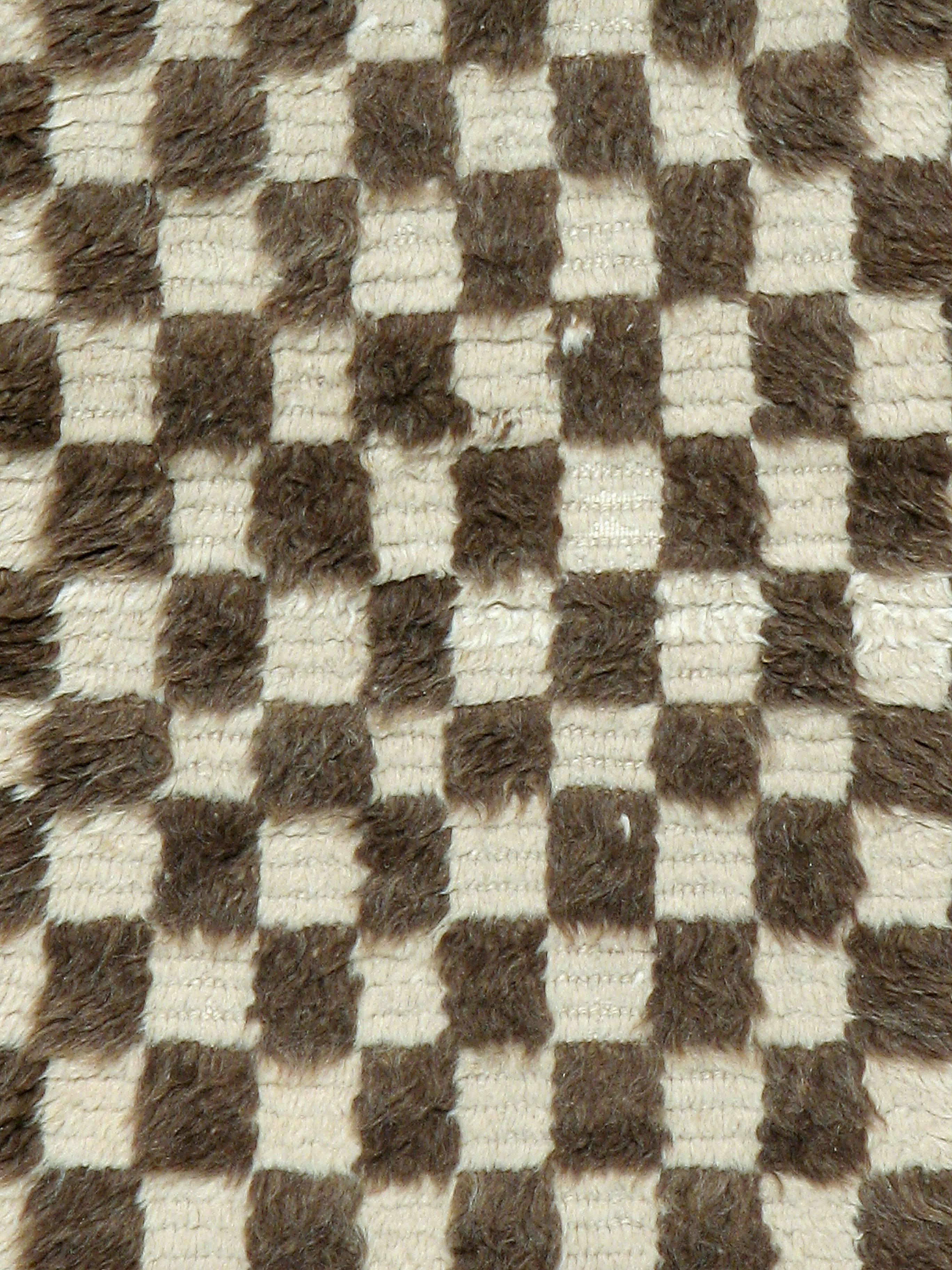 A vintage Turkish Konya carpet from the mid-20th century featuring a brown and white checkerboard ground.