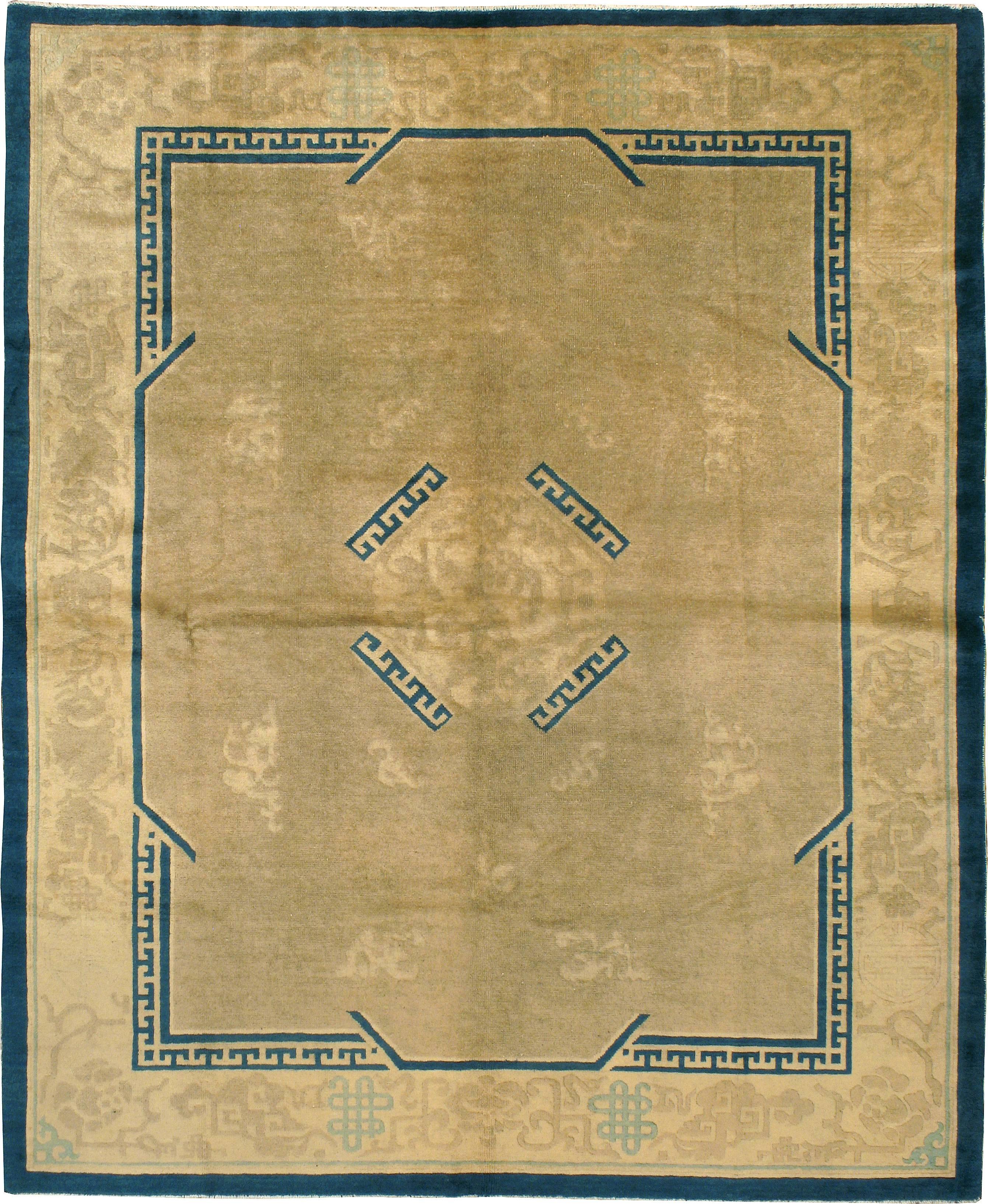 An antique Chinese Peking carpet from the first quarter of the 20th century with a wheat ground and blue accents.