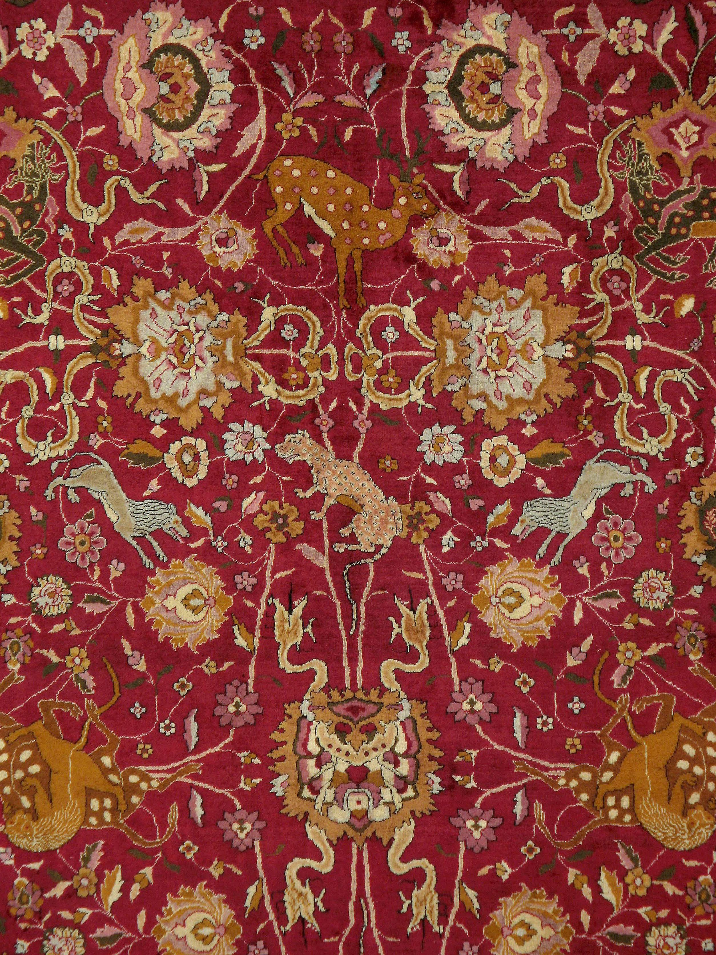 An antique Indian Lahore carpet, from the first quarter of the 20th century, with an allover pictorial design over a red field.
