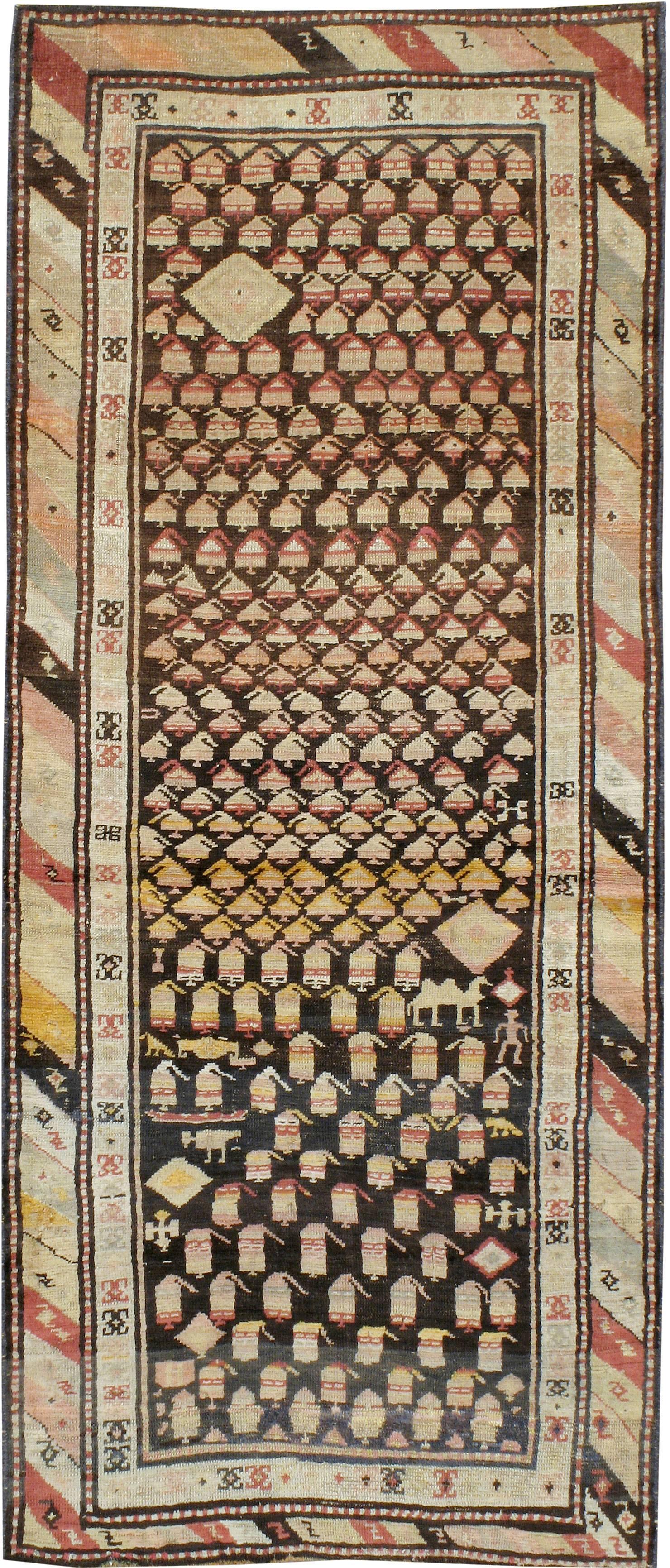 An antique Persian Kurd carpet from the first quarter of the 20th century with an asymmetrical design consisting of angular paisleys and figurines.