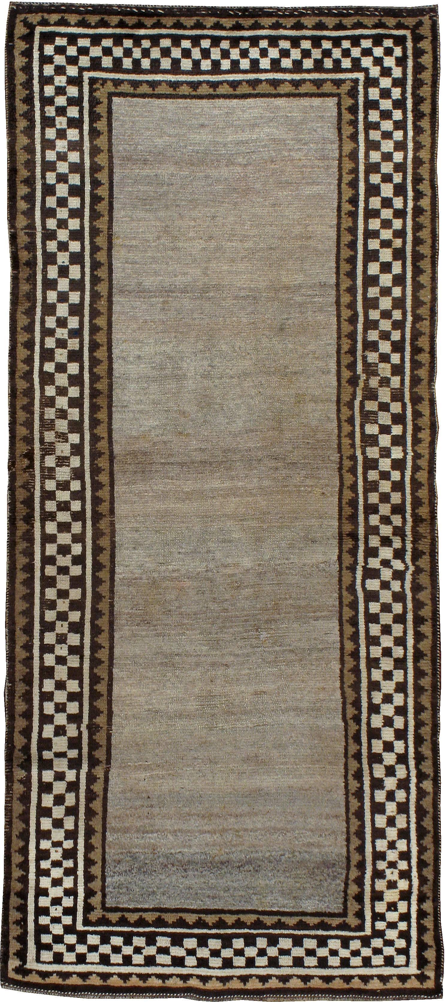 An antique tribal Persian Gabbeh carpet from the second quarter of the 20th century with an unpretentious-folksy appeal.