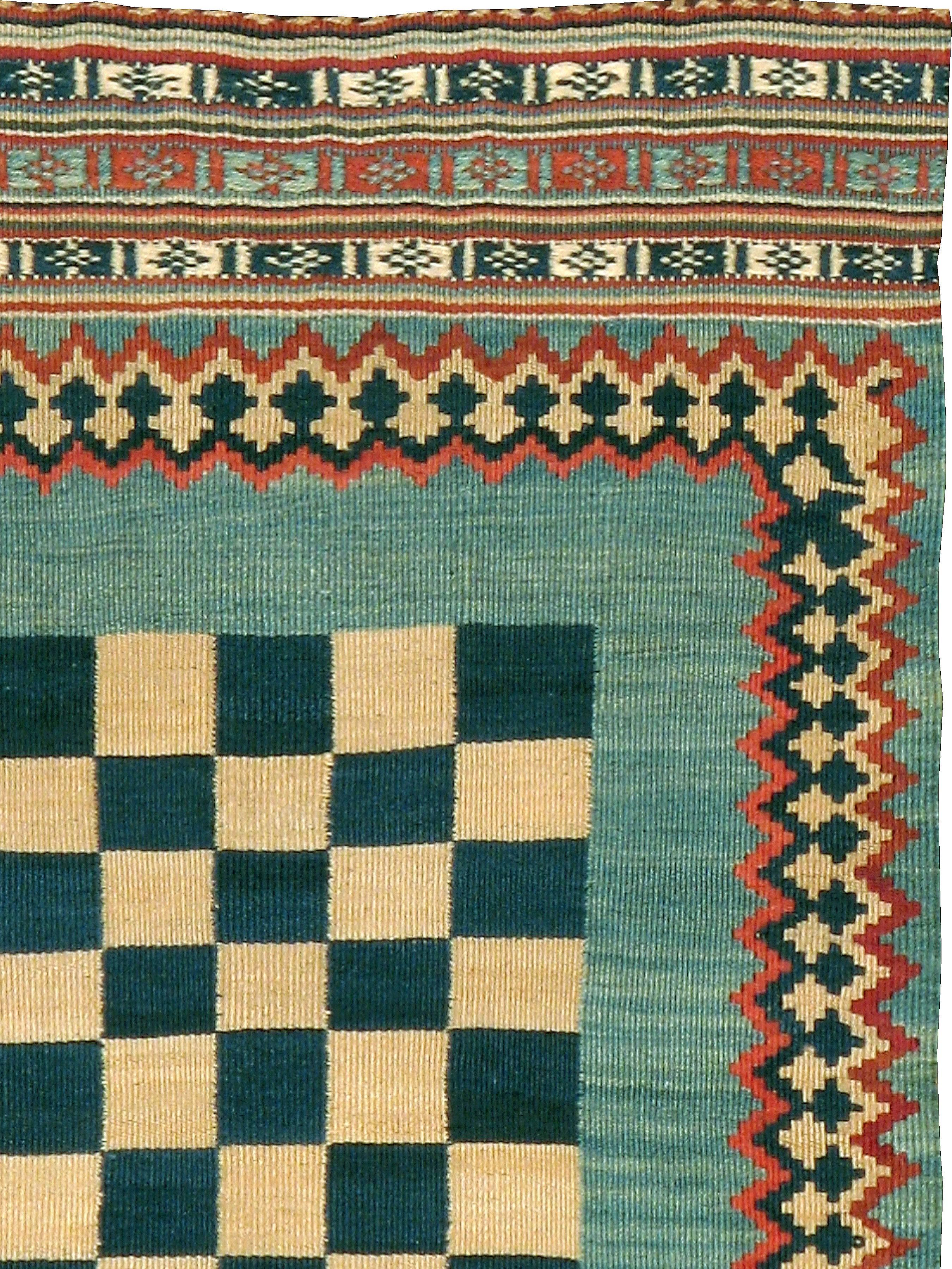 A vintage Persian flat-woven Kilim carpet from the mid-20th century.