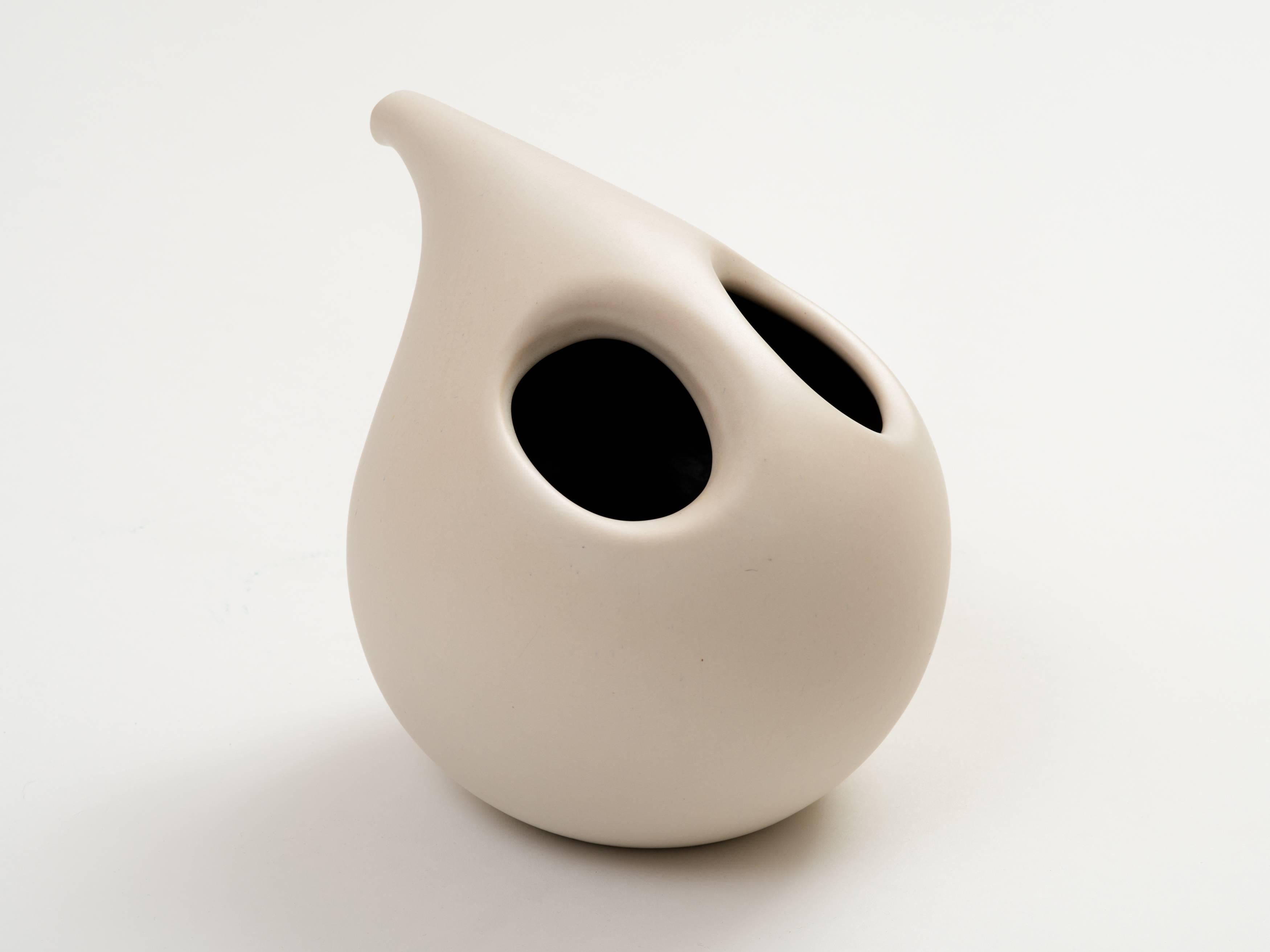 An intriguing slipcast ceramic vase resembling a pitcher or decanter with a faux spout and two openings at top that create a handle. Such a pleasing and well-proportioned modernist design, finished in a matte white glaze (interior glaze is black). A
