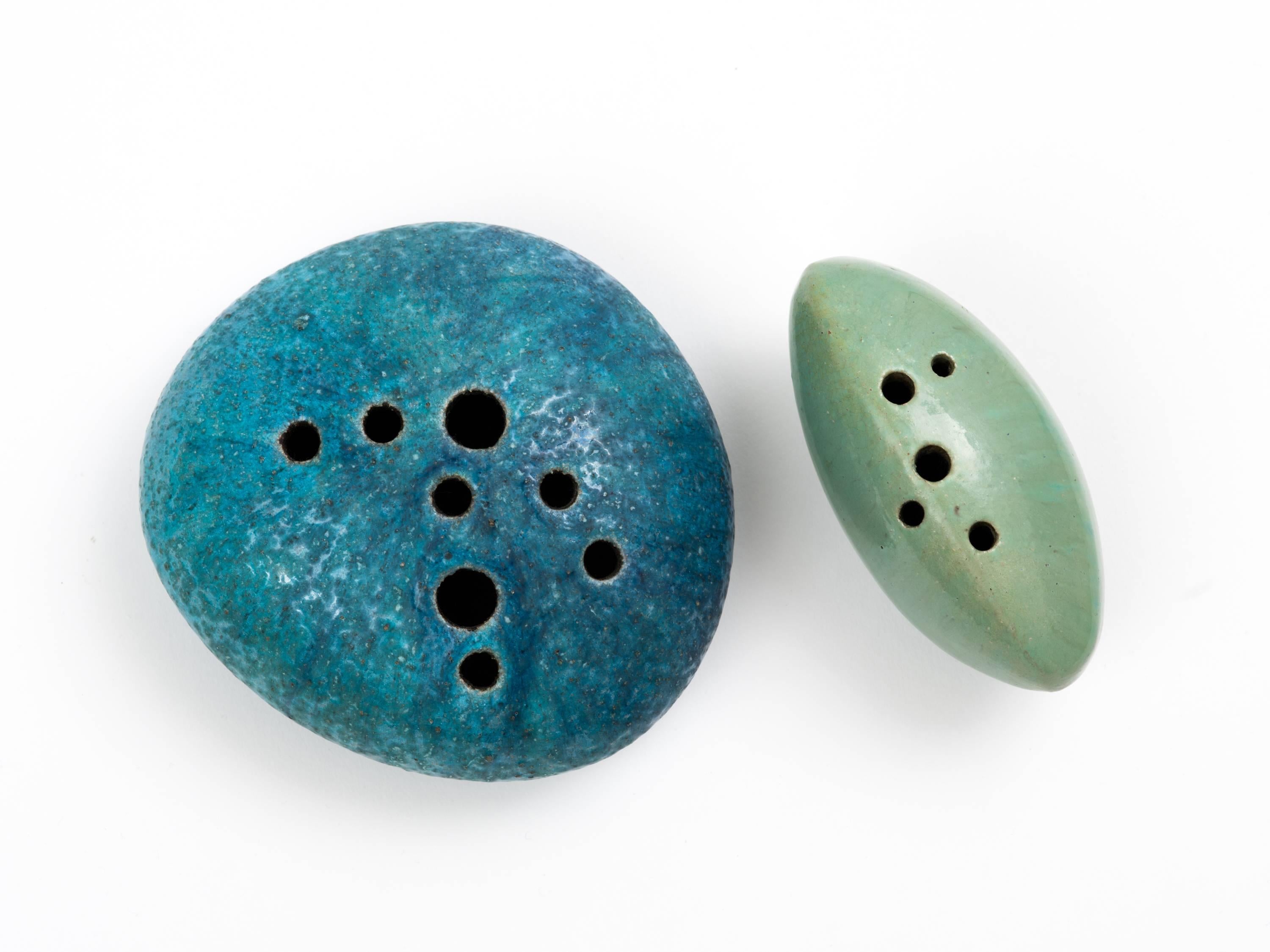 A pair of glazed earthenware Sassi (stones) sculptures in shades of Mediterranean blue and sea foam green by Renato Bassoli (1915-1982). Bassoli was a multi-disciplined artist with earlier career credits in both graphic and set design before moving