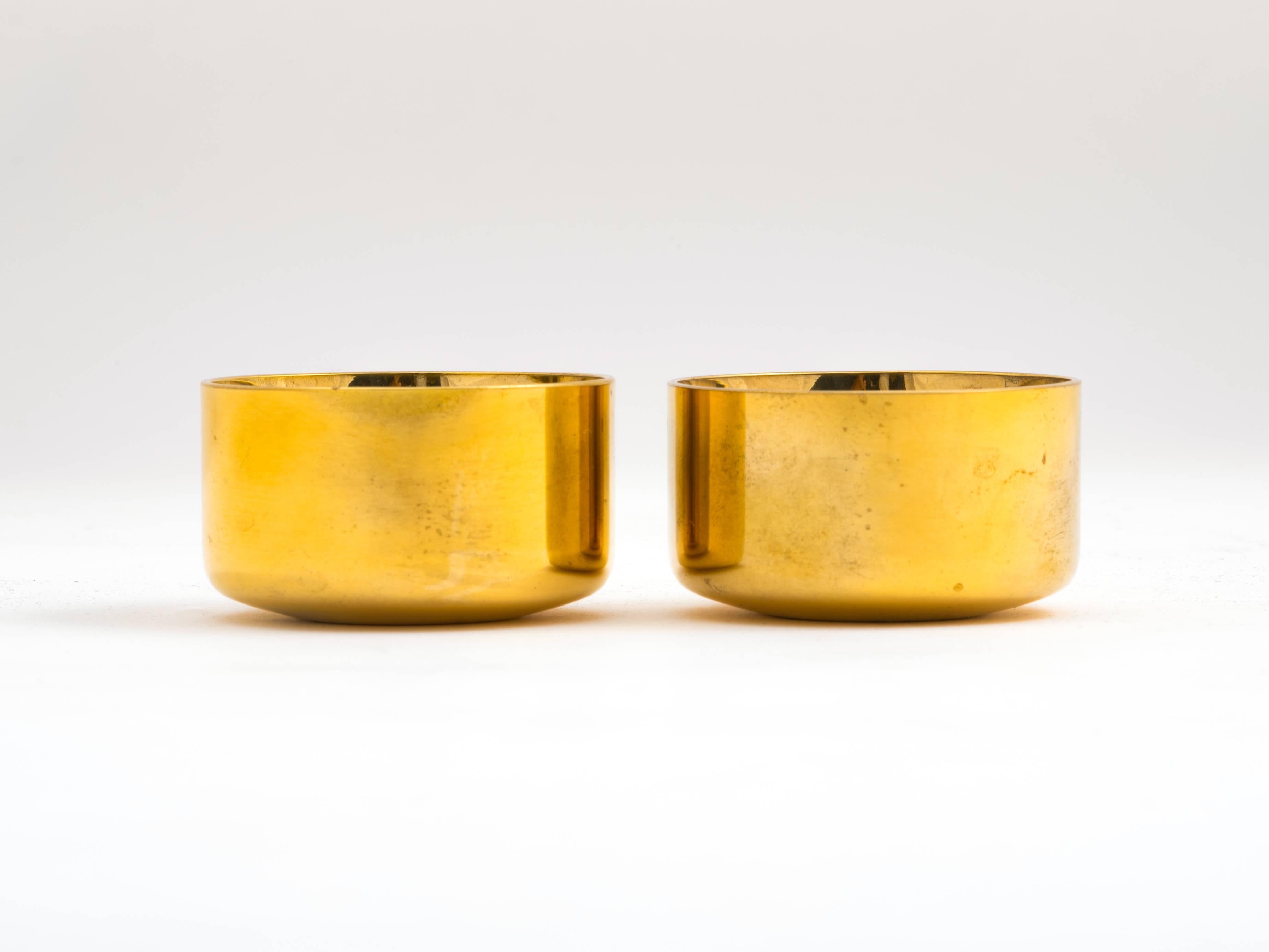 A pair of solid brass shot or cordial cups plated in 23-karat gold, designed by Pierre Forssell for Skultuna, Sweden. Referred to as 'snaps' glasses in Scandinavia, they have rounded interiors and are double-walled to keep your drink cold. Elegant,