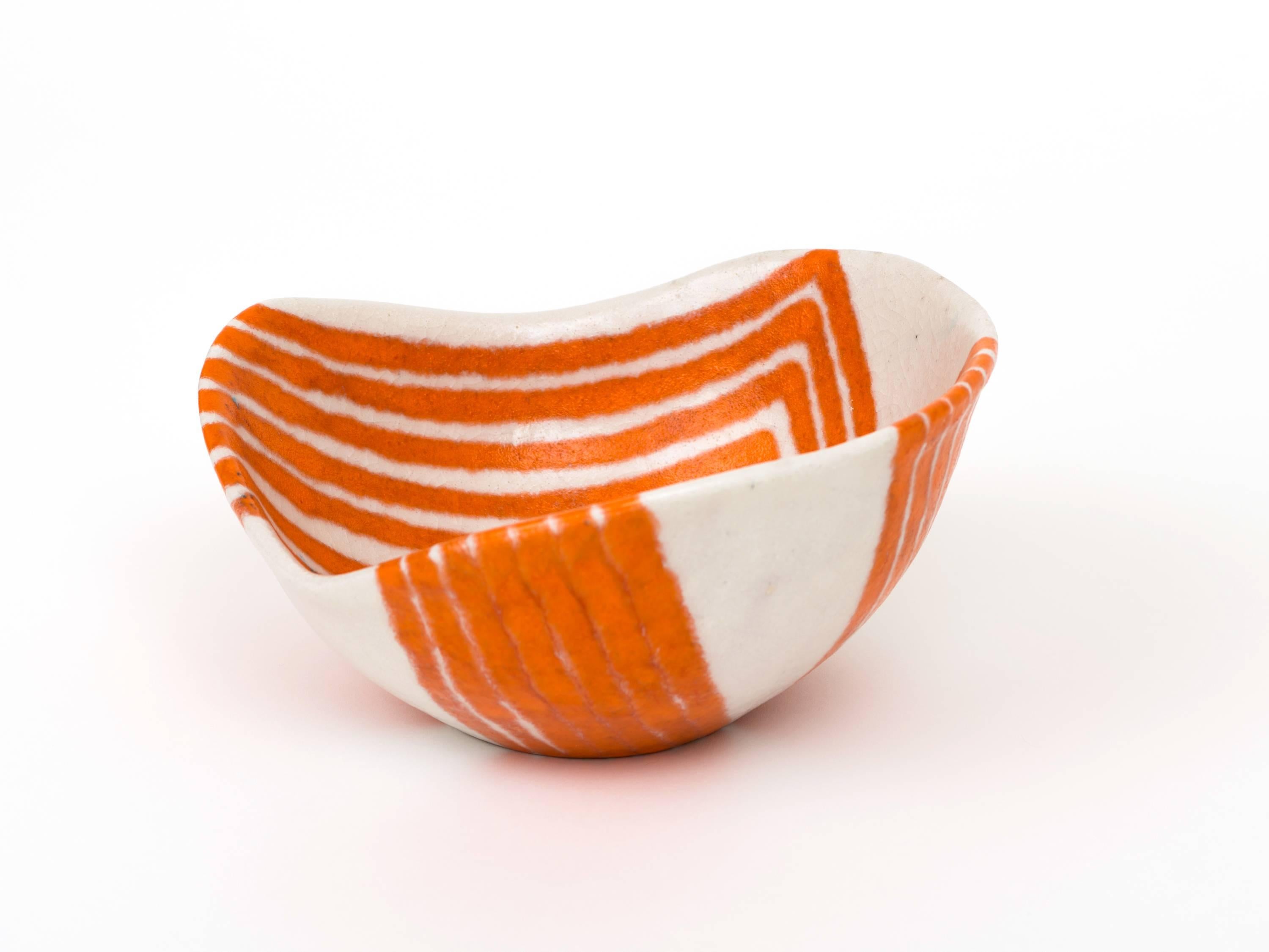 A graphic, hand-thrown bowl by Guido Gambone in a creamsicle colorway with applied tribal motif decoration and an undulating rim. Captivating design with nice scale - - it's larger than it appears in these images so please refer to dimensions and