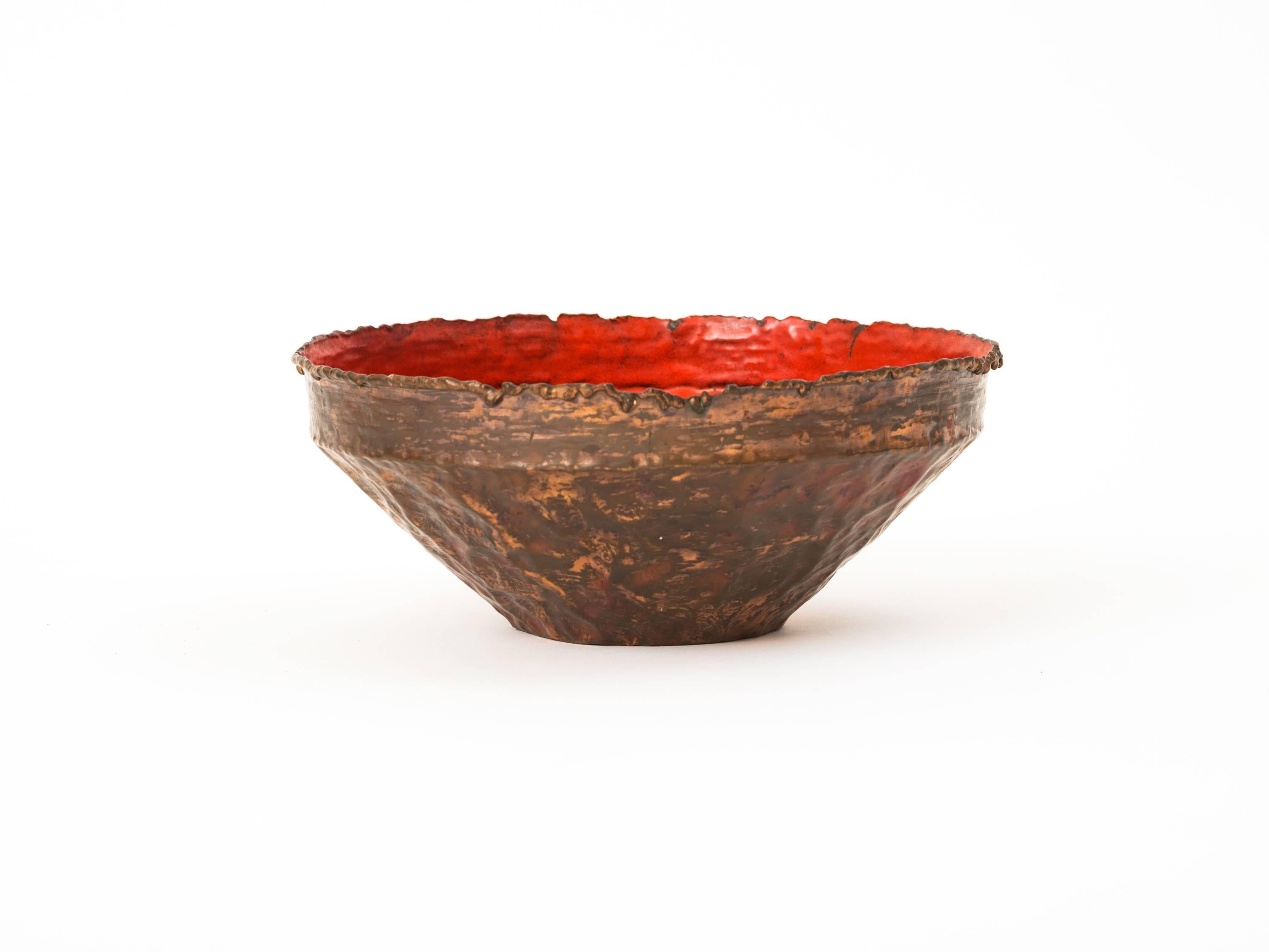 Decorative bowl in the Brutalist style, executed in handwrought copper with a torch-cut edge and a fiery-red enamel to the interior designed by Marcello Fantoni and imported by Raymor. A visually-arresting and tactile design object. Embossed to the