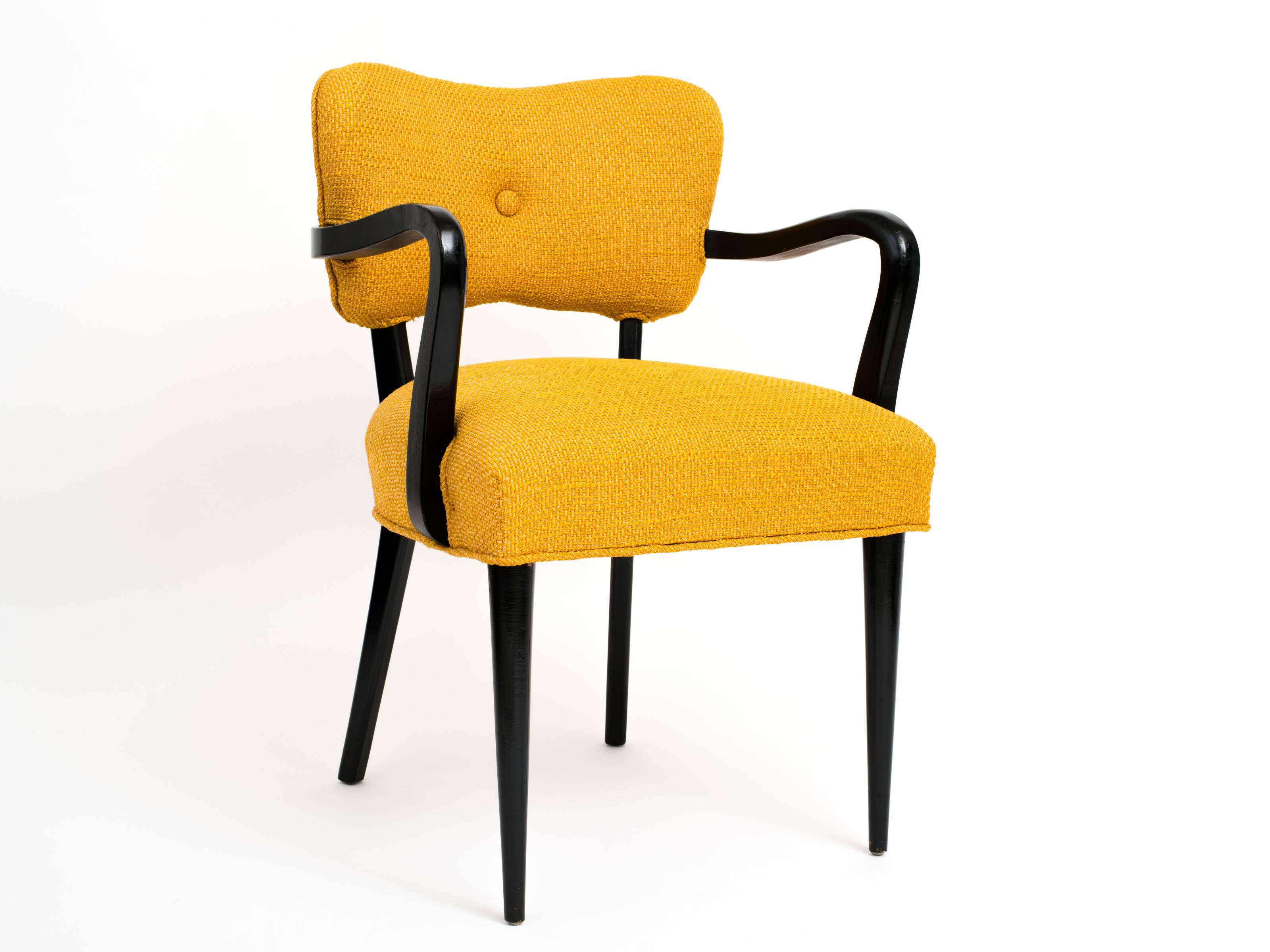 A timeless and well-built pair of modernist side chairs with ebonized, solid wood frames and with their original, creamsicle-colored wool upholstery. Rounded and tapered front legs against square rear legs, all being slightly flared which nicely