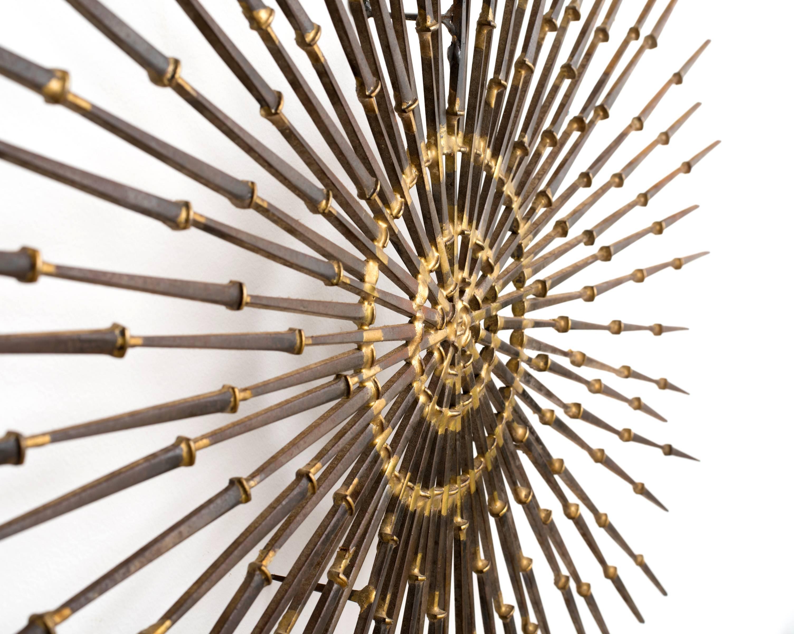 Classic modernist sunburst or starburst wall art executed entirely in braze welded masonry nails. By Ron Schmidt. Circa 1969.

*floats 2.25 inches from wall