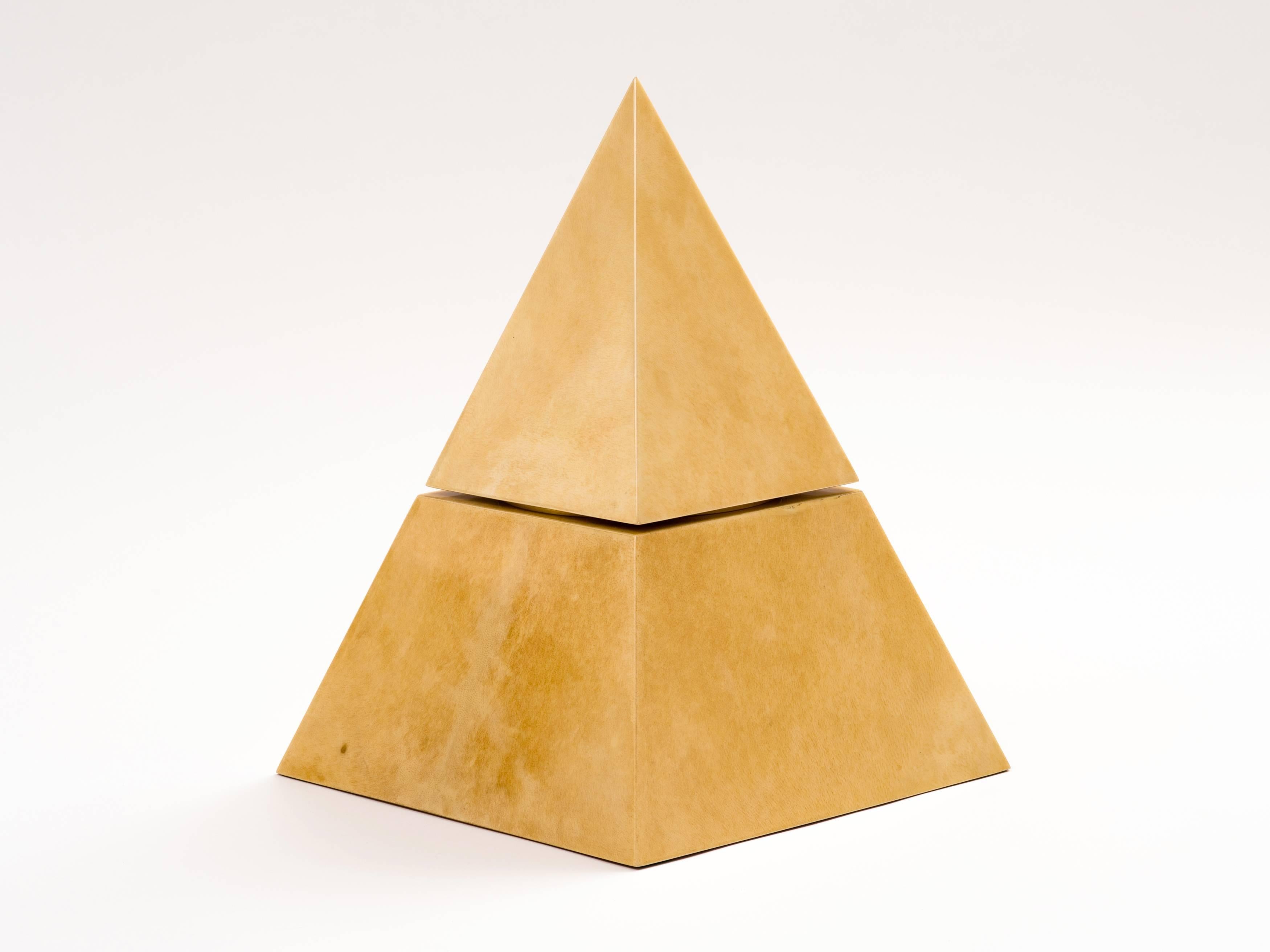 An exceptional example of an uncommon Aldo Tura design, this pyramid form wine cooler or ice bucket comprises a lacquered goatskin parchment body with a lacquered mahogany underside, inset with a plastic receptacle. The goatskin is a rich cream or