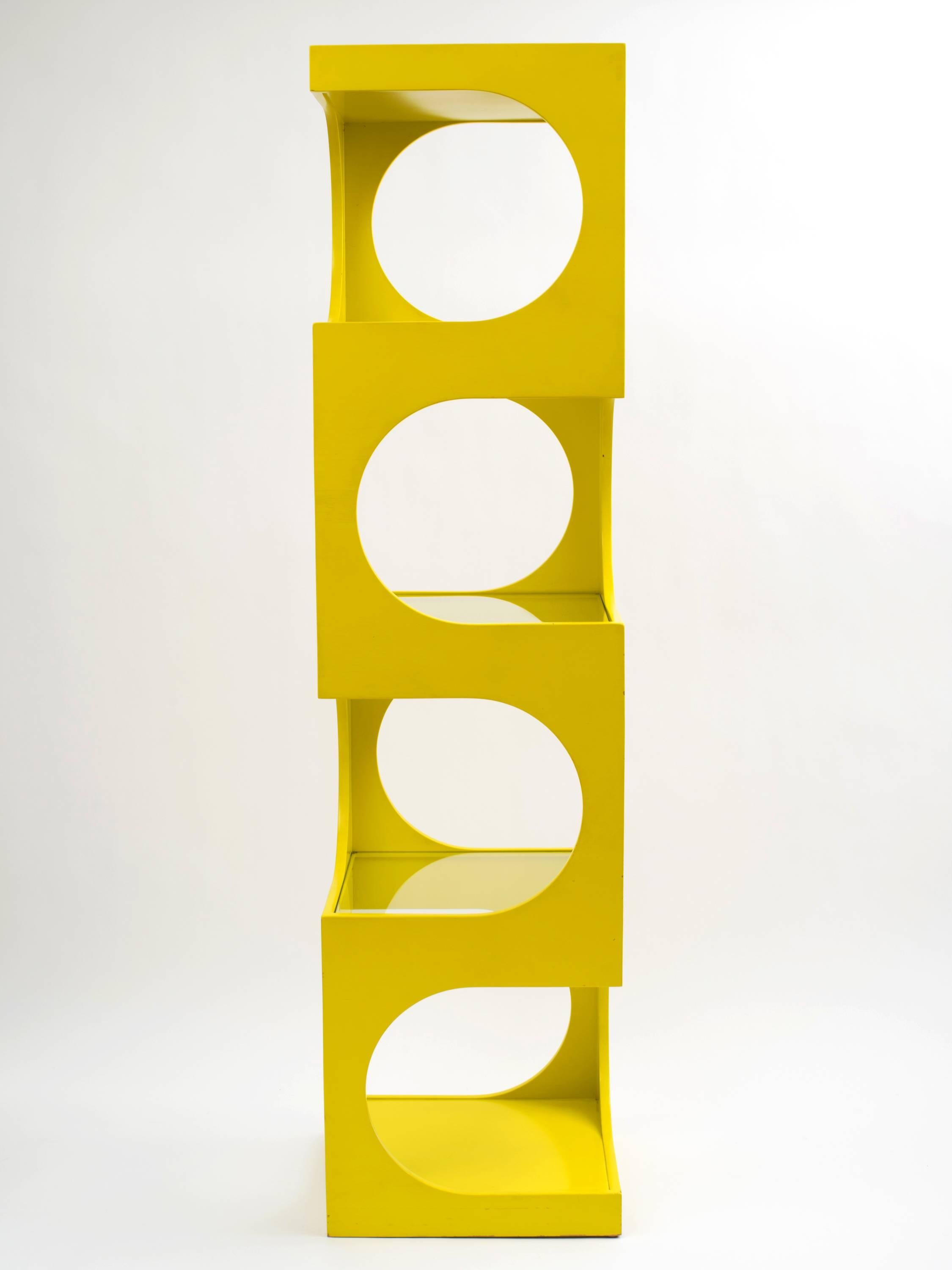 A shelving unit designed by Edward Wormley for Dunbar comprising a hardwood frame in an optical art design with three glass shelves and a solid bottom shelf. It retains its original yellow / yellow chartreuse satin lacquer which is impressively