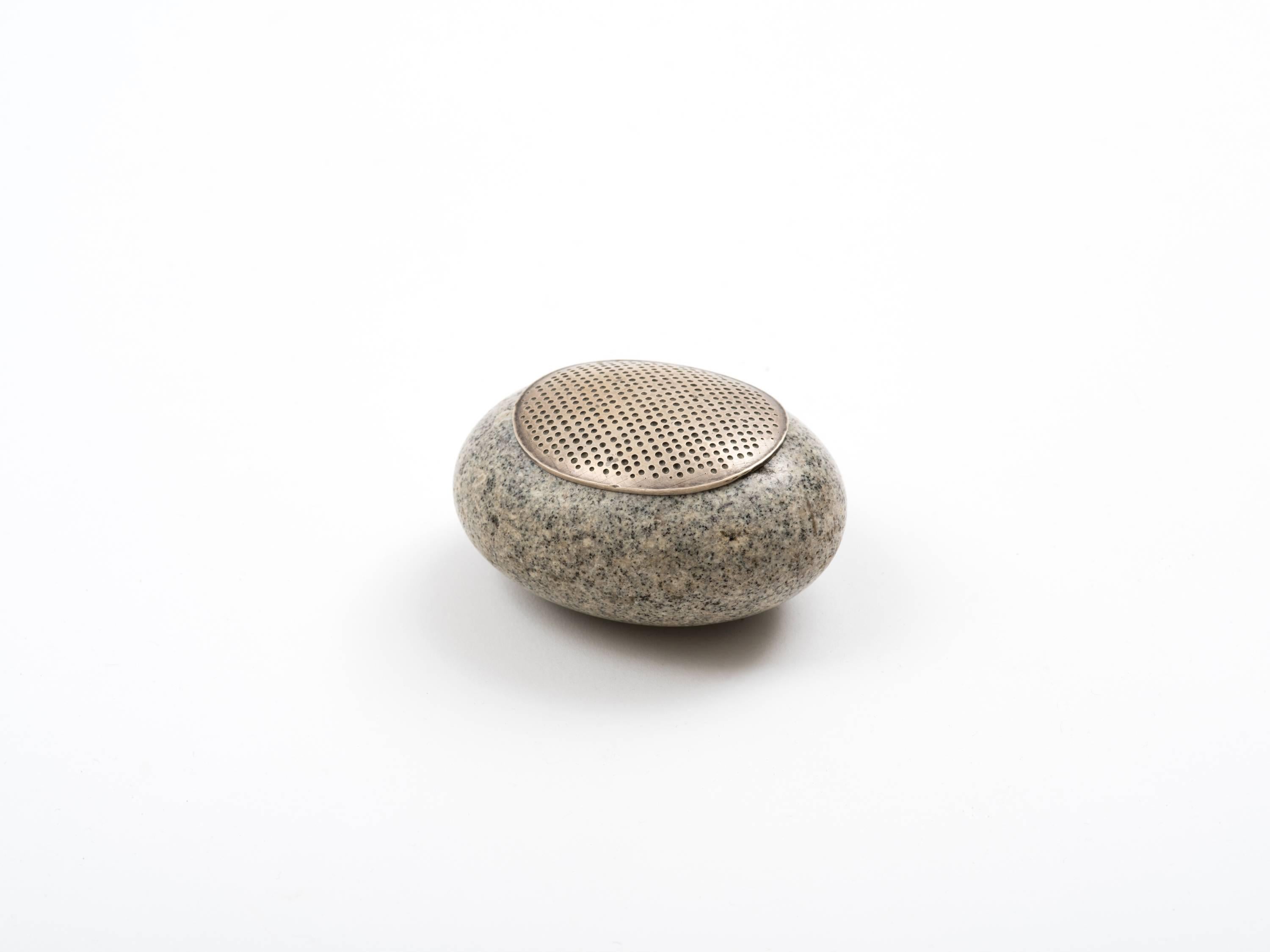 A sublime box handcrafted by American silversmith, John Prip, comprising a hollowed and polished granite river stone inset with rim and finished with a handwrought lid, both in sterling silver. Meticulously executed and thoughtfully designed with