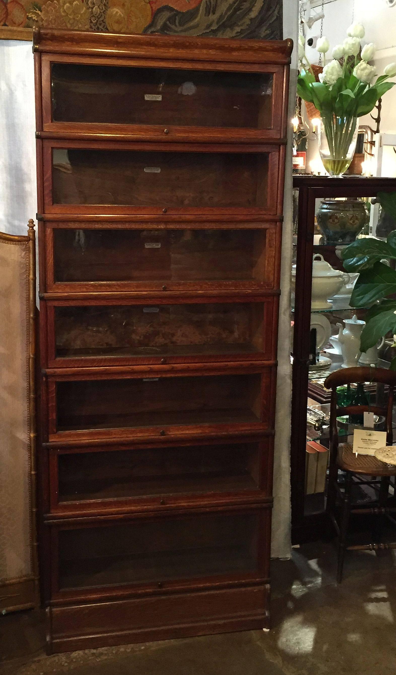 A tall English lawyer's or solicitor's stacking bookcase of oak and glass by the celebrated furniture-makers, Globe-Wernicke.

Includes a fitted moulded top, seven compartments with sliding glass fronts, and fitted moulded base. (Breaks down into