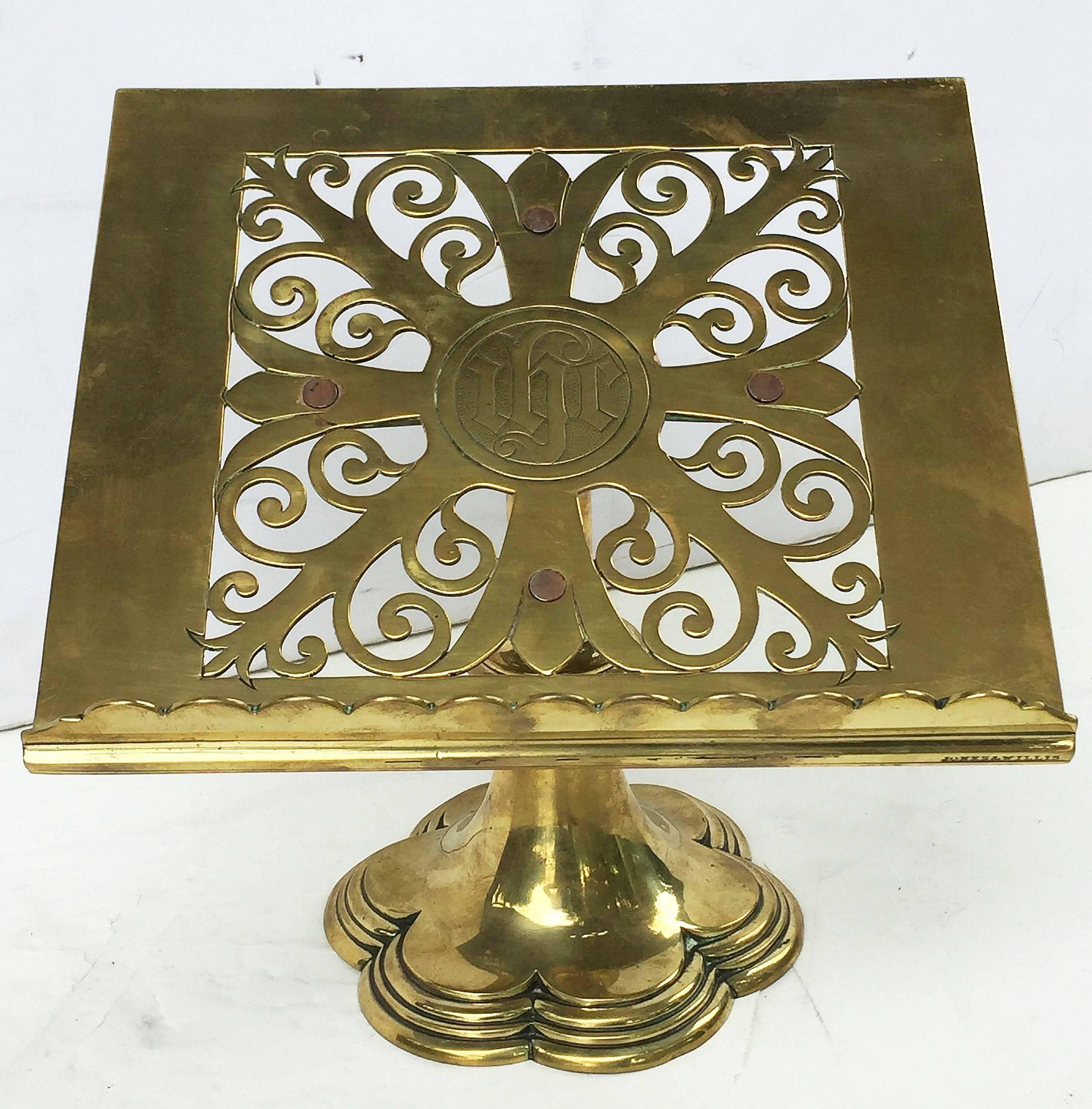 A fine English table top lectern, missal or book stand of brass, featuring a Christian symbol or Christogram in the center reading IHC here deriving from the Greek word for Christ. The top attached to a weighted base.

Marked on base edge Jones &
