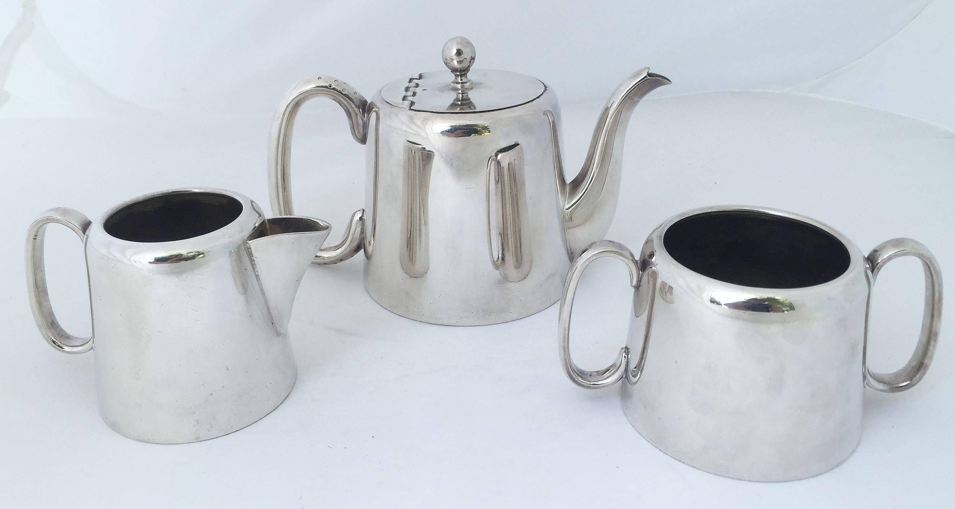 A fine English three-piece hotel silver tea set, featuring a tea pot with hinged lid, cream and sugar. Marked - Made in Sheffield, England.

 Tea Pot   H 5